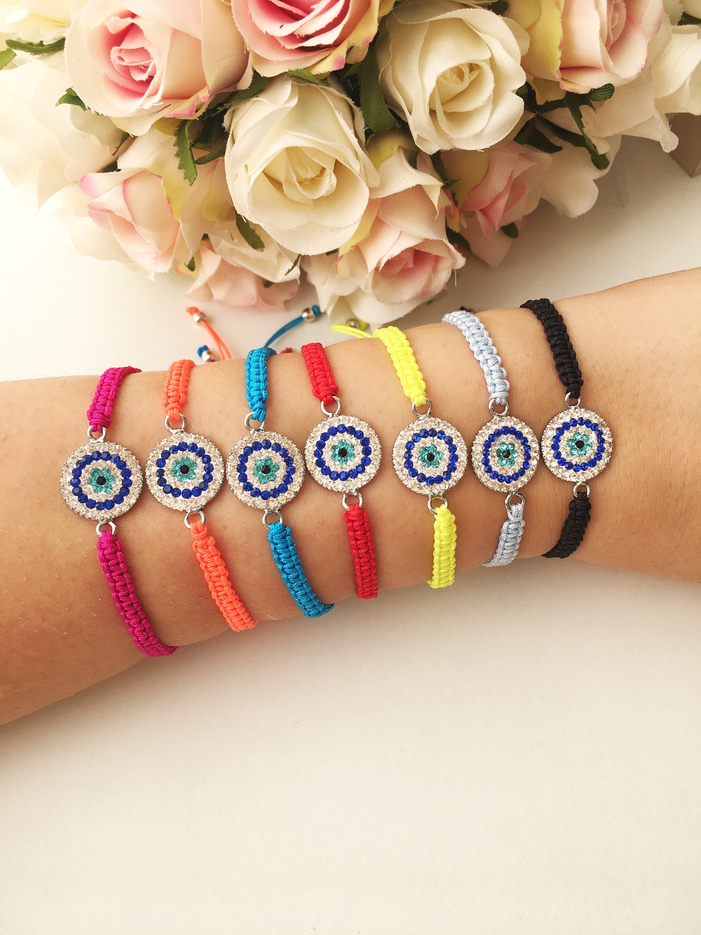 Handmade Macrame Evil Eye Bracelet with silver-plated hamsa hand charm, adjustable black cord.