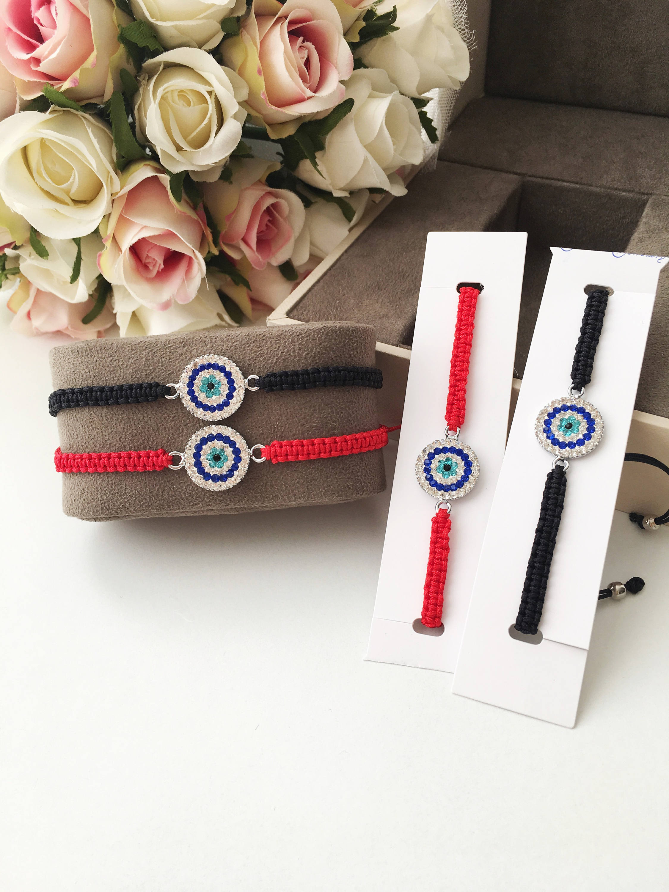 Handmade Macrame Evil Eye Bracelet with silver-plated hamsa hand charm, adjustable black cord.