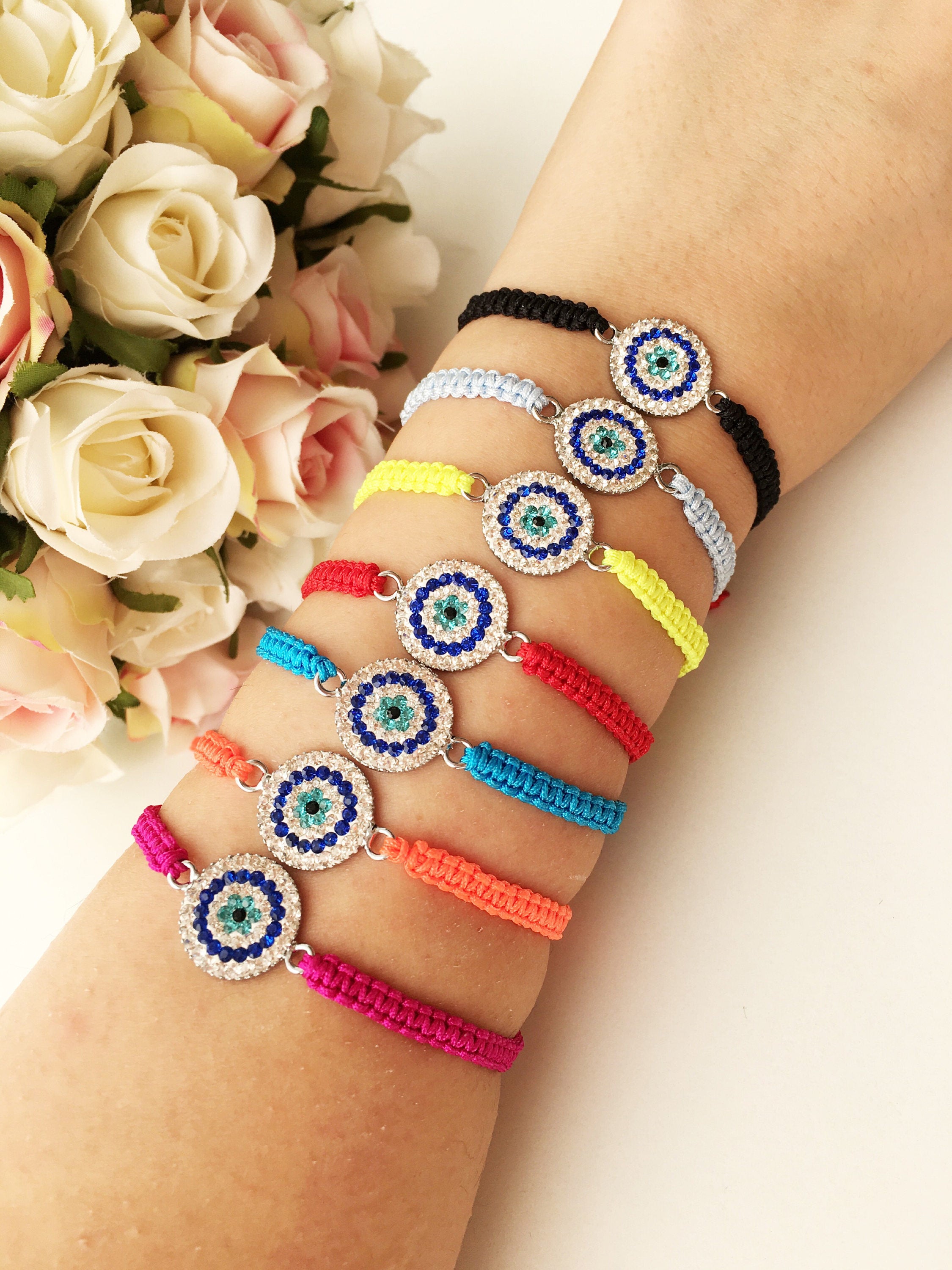 Handmade Macrame Evil Eye Bracelet with silver-plated hamsa hand charm, adjustable black cord.