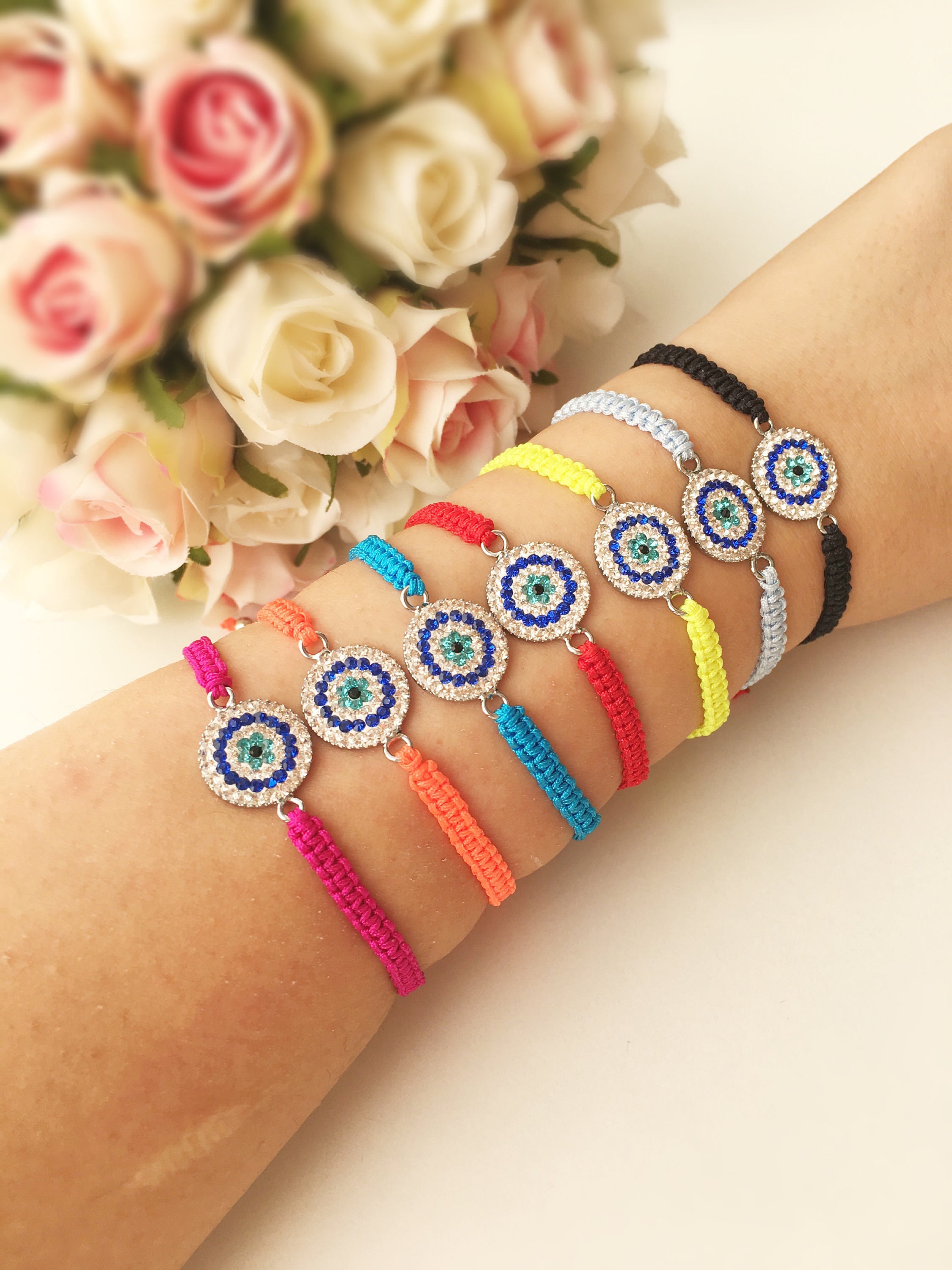 Handmade Macrame Evil Eye Bracelet with silver-plated hamsa hand charm, adjustable black cord.