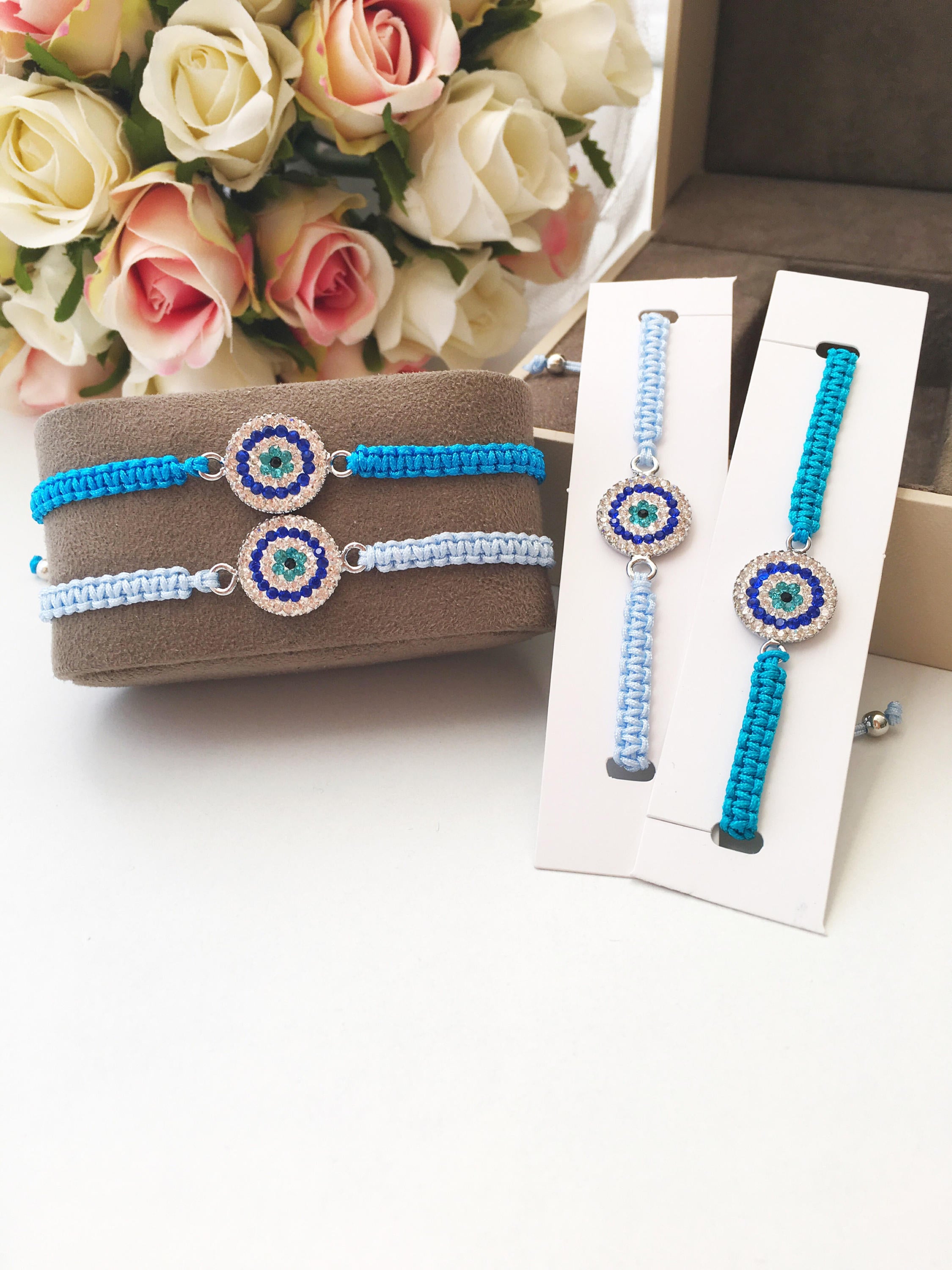 Handmade Macrame Evil Eye Bracelet with silver-plated hamsa hand charm, adjustable black cord.