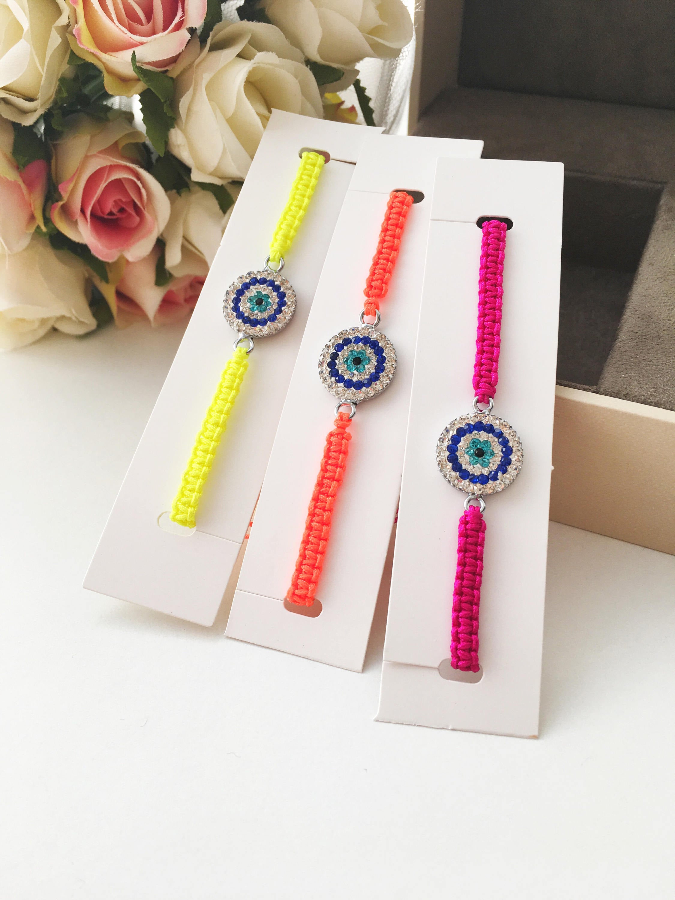 Handmade Macrame Evil Eye Bracelet with silver-plated hamsa hand charm, adjustable black cord.