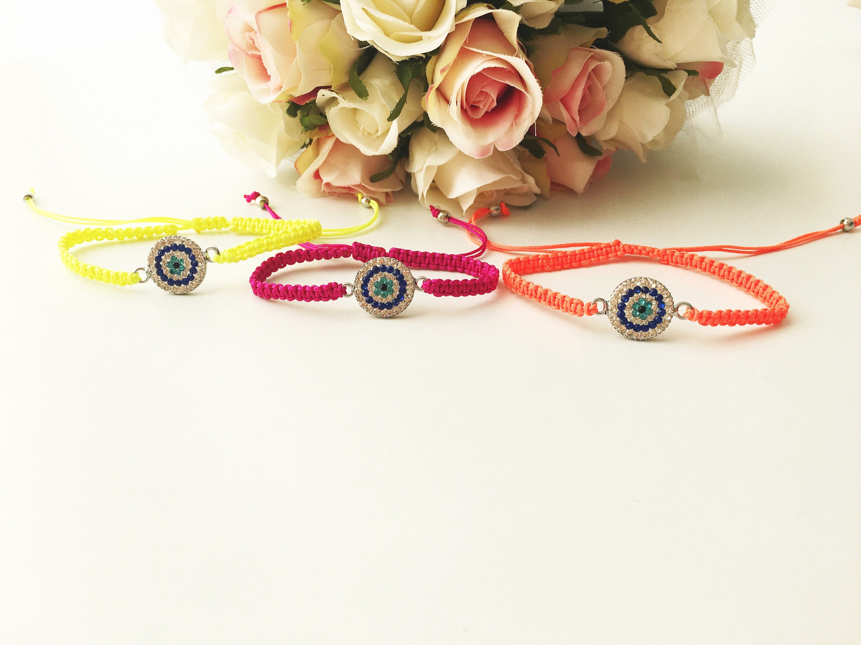 Handmade Macrame Evil Eye Bracelet with silver-plated hamsa hand charm, adjustable black cord.