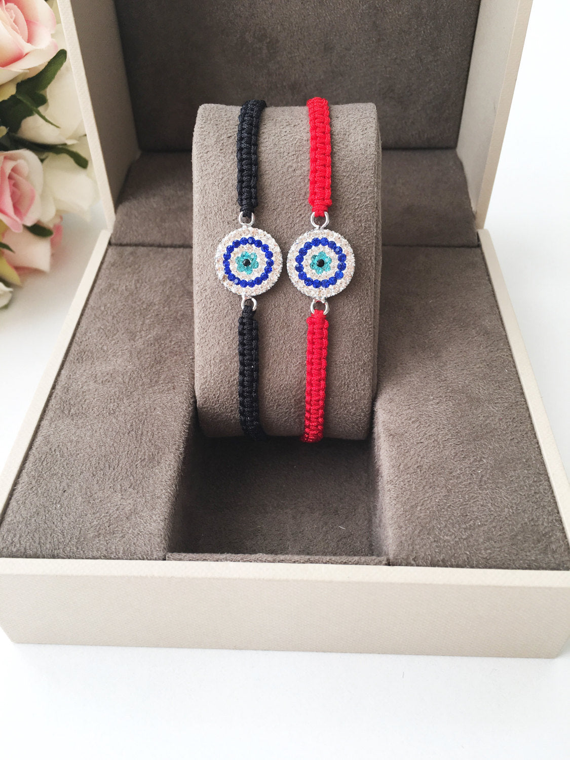 Handmade Macrame Evil Eye Bracelet featuring red and black strings with an evil eye charm, adjustable for all wrist sizes.