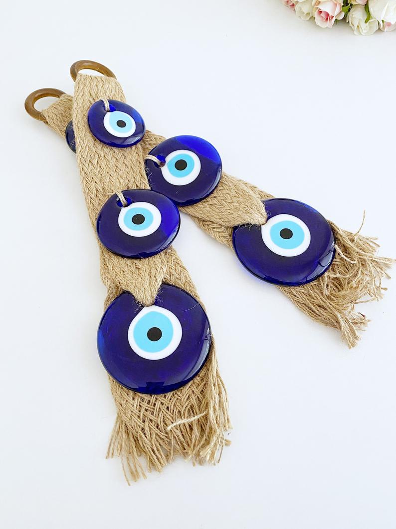 A beautifully crafted macrame wall hanging featuring blue evil eye beads, symbolizing protection and elegance in home decor.