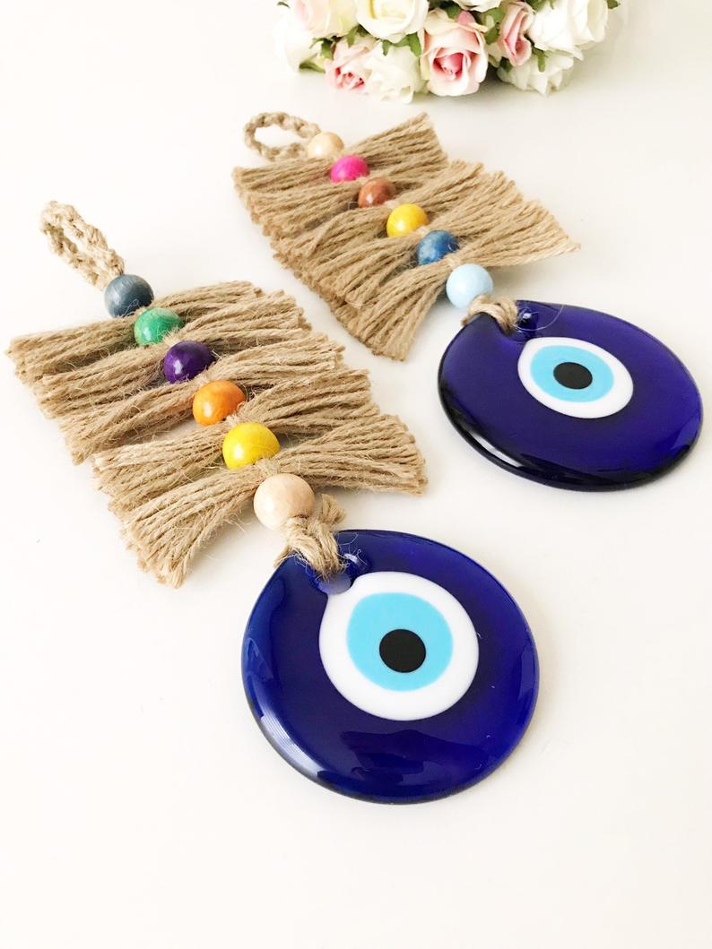 A beautifully crafted macrame evil eye wall hanging featuring colorful beads and intricate knots, symbolizing protection and good luck.