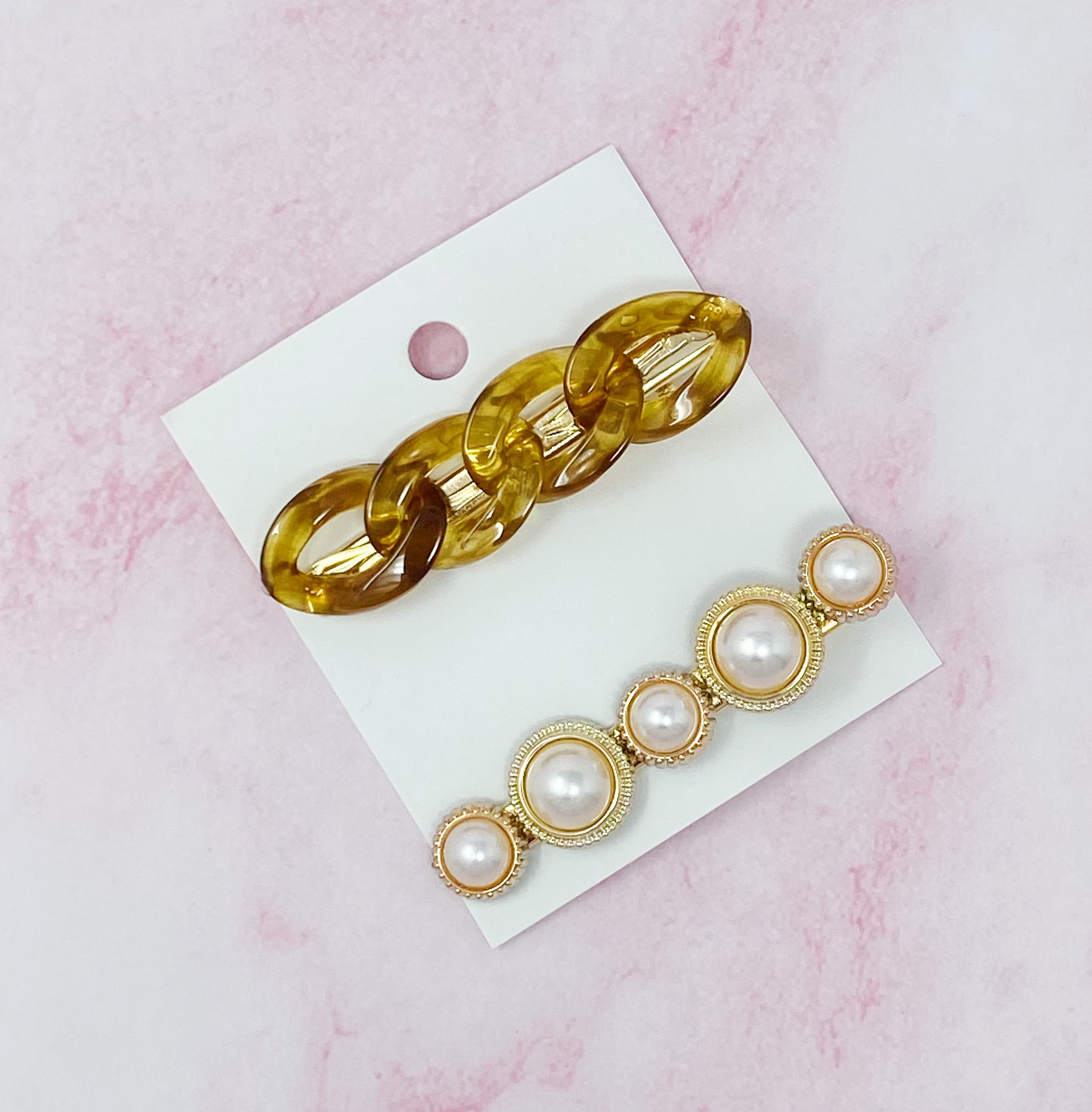 A stylish Marble Chain and Pearl Hair Clip Set featuring two elegant clips with neutral marble chains and pearl accents.
