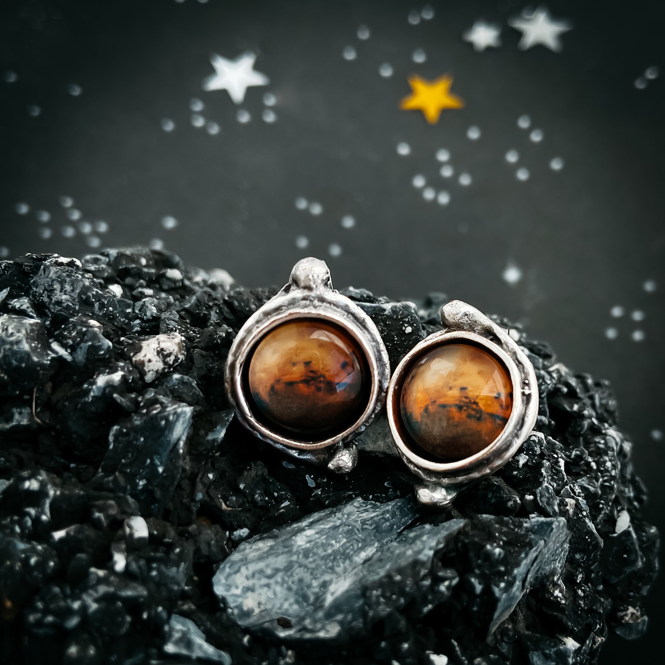 A pair of handcrafted Mars and Moons Earrings featuring the red planet Mars with silver beads representing its moons, Deimos and Phobos.