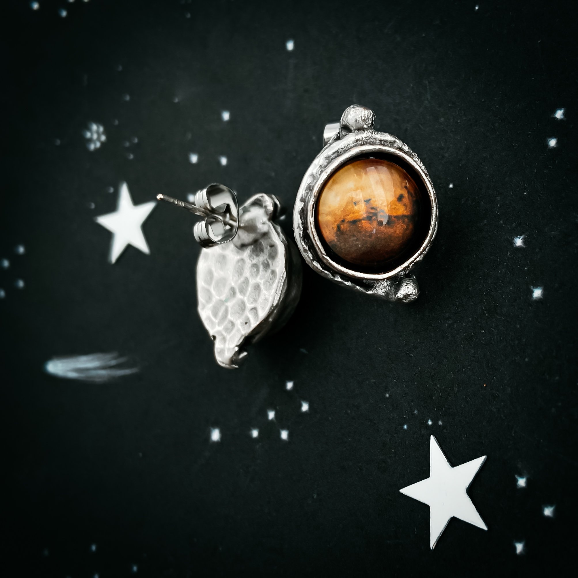 A pair of handcrafted Mars and Moons Earrings featuring the red planet Mars with silver beads representing its moons, Deimos and Phobos.