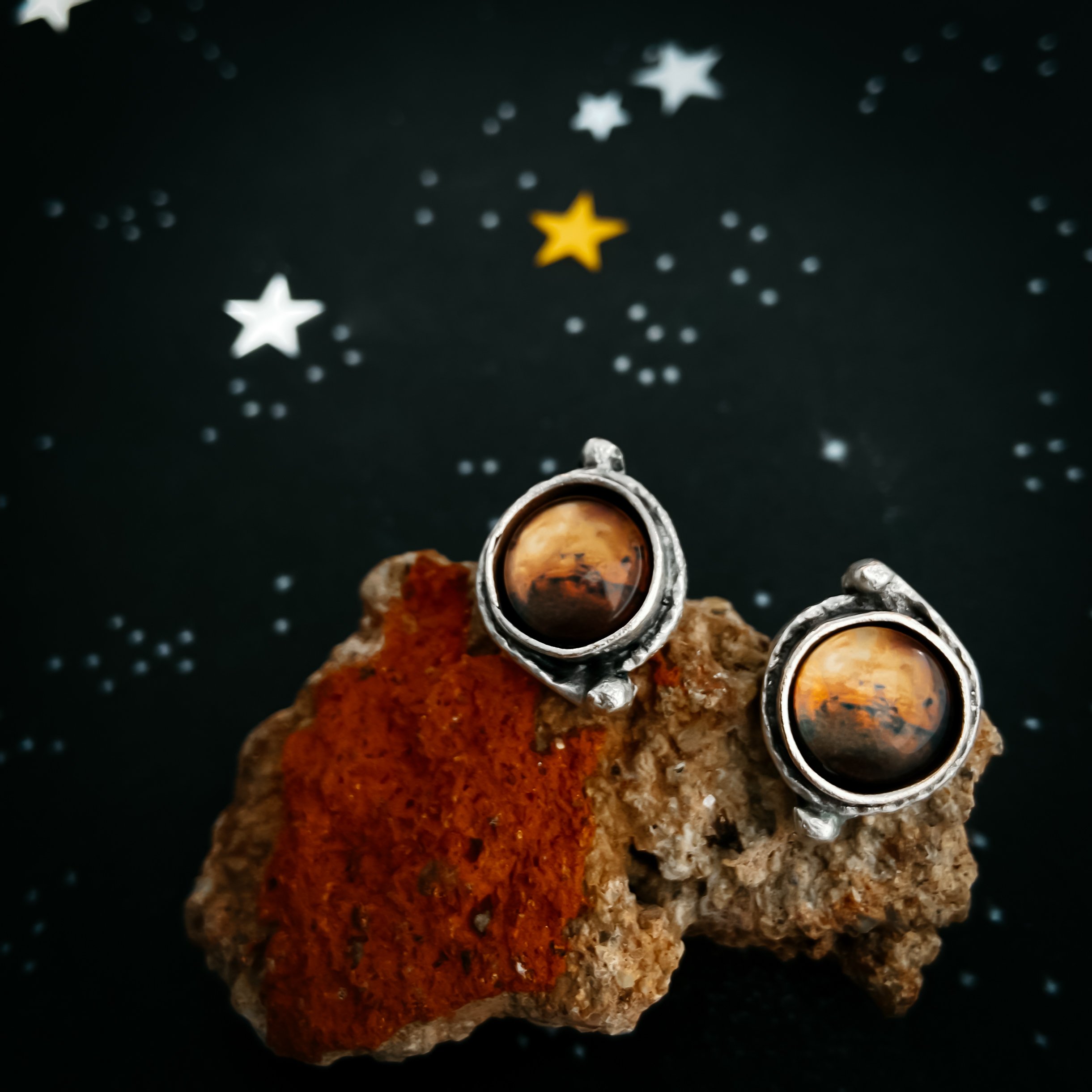 A pair of handcrafted Mars and Moons Earrings featuring the red planet Mars with silver beads representing its moons, Deimos and Phobos.