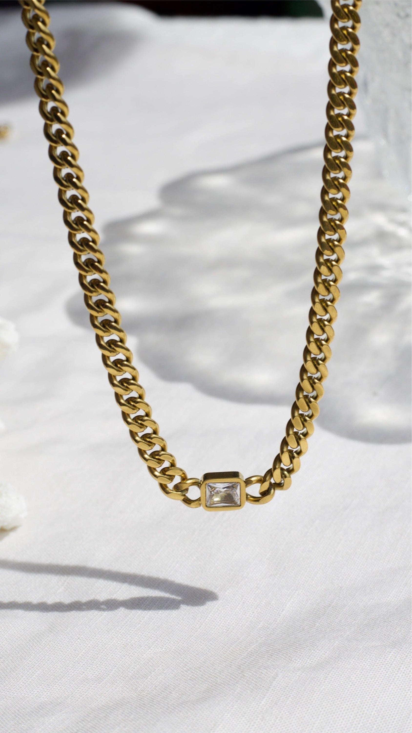 Martha Cuban Link Chain 8mm in rich gold with diamond cut emerald and clear CZ crystals, showcasing its chunky design and adjustable length.
