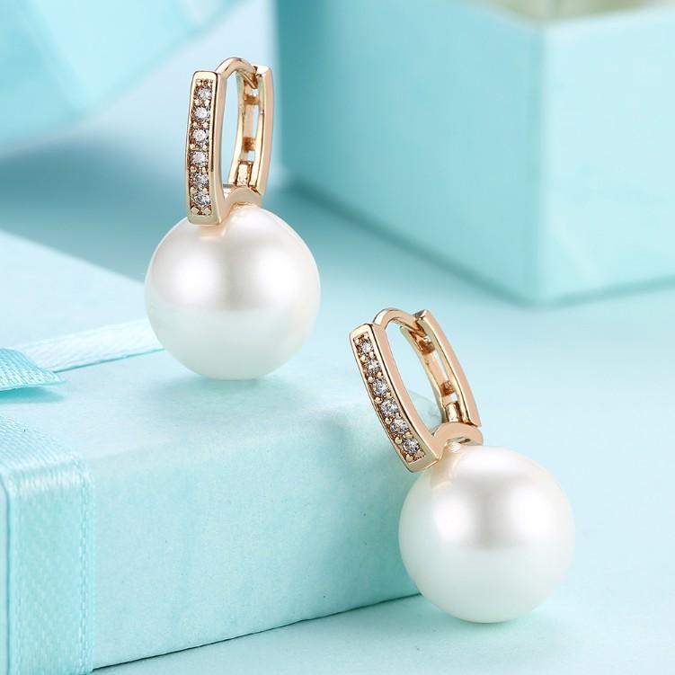 Micro-Pav'e Austrian Crystal Curved Pearl Huggie Earrings set in 18K gold, showcasing their elegant design and sparkling crystals.