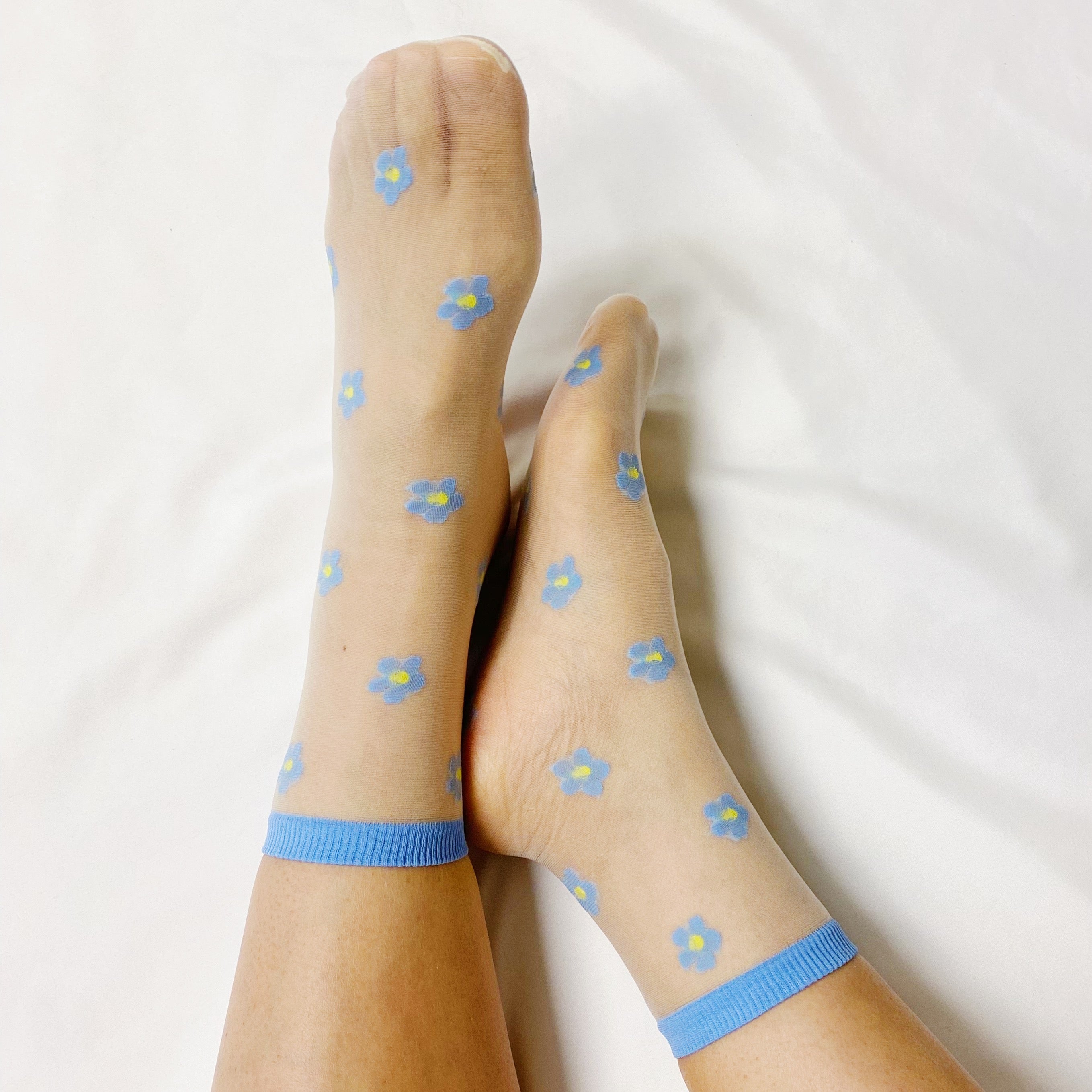 A set of two pairs of mini flower sheer socks, featuring a delicate floral design on a lightweight sheer fabric.