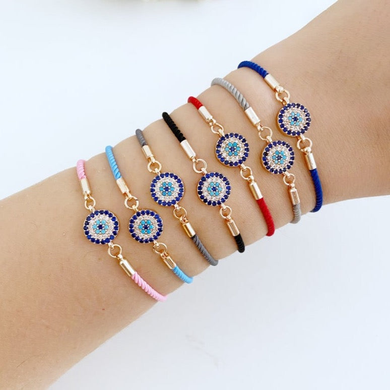 Minimal Evil Eye Bracelet featuring a rose gold charm on an adjustable cotton cord, showcasing its elegant design and craftsmanship.