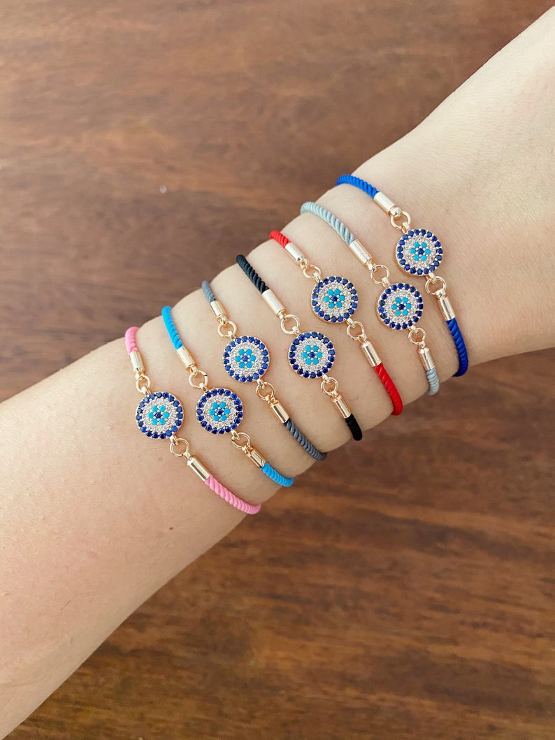 Minimal Evil Eye Bracelet featuring a rose gold charm on an adjustable cotton cord, showcasing its elegant design and craftsmanship.