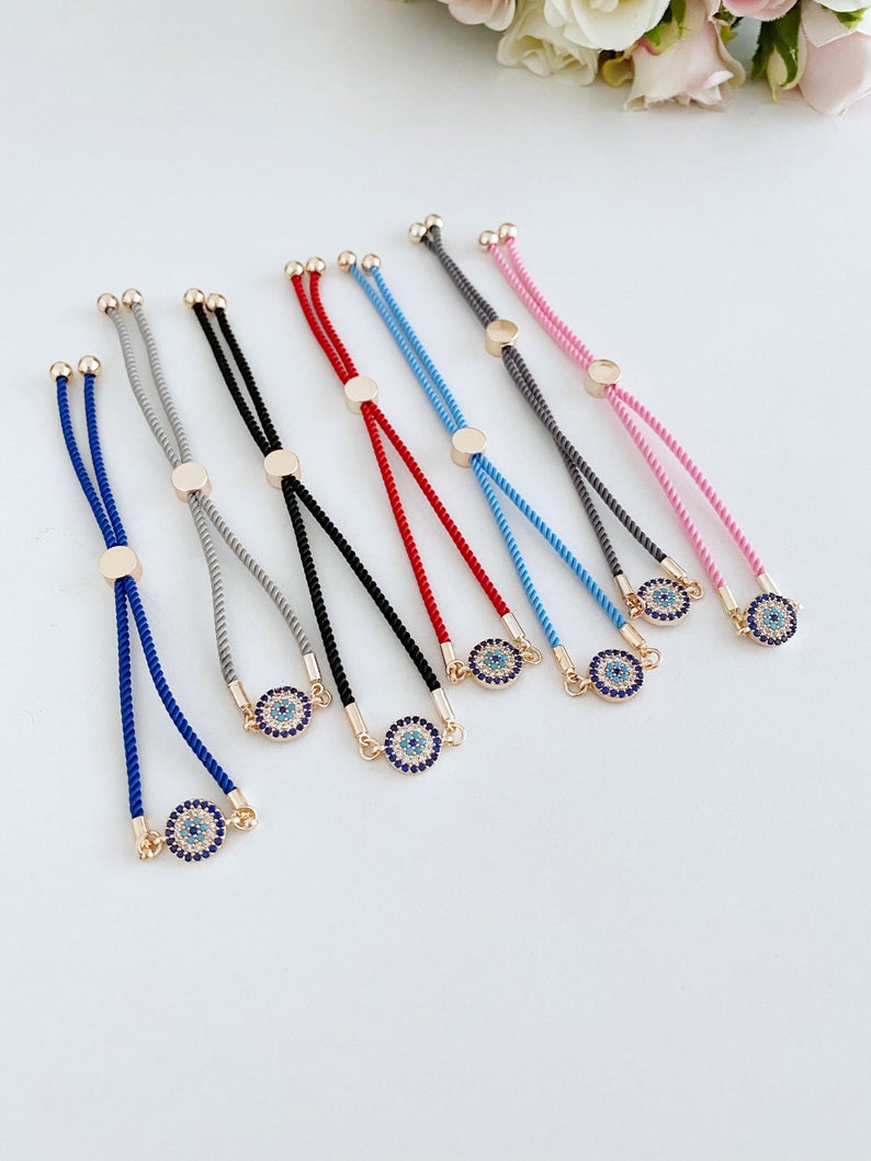 Minimal Evil Eye Bracelet featuring a rose gold charm on an adjustable cotton cord, showcasing its elegant design and craftsmanship.