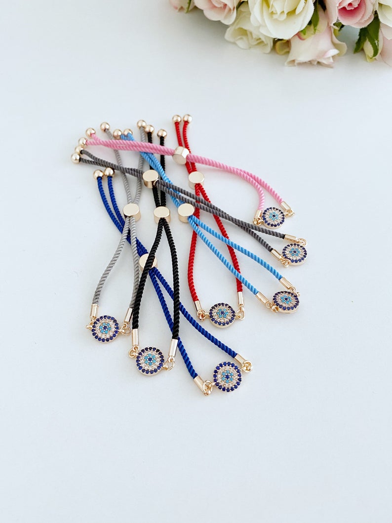 Minimal Evil Eye Bracelet featuring a rose gold charm on an adjustable cotton cord, showcasing its elegant design and craftsmanship.