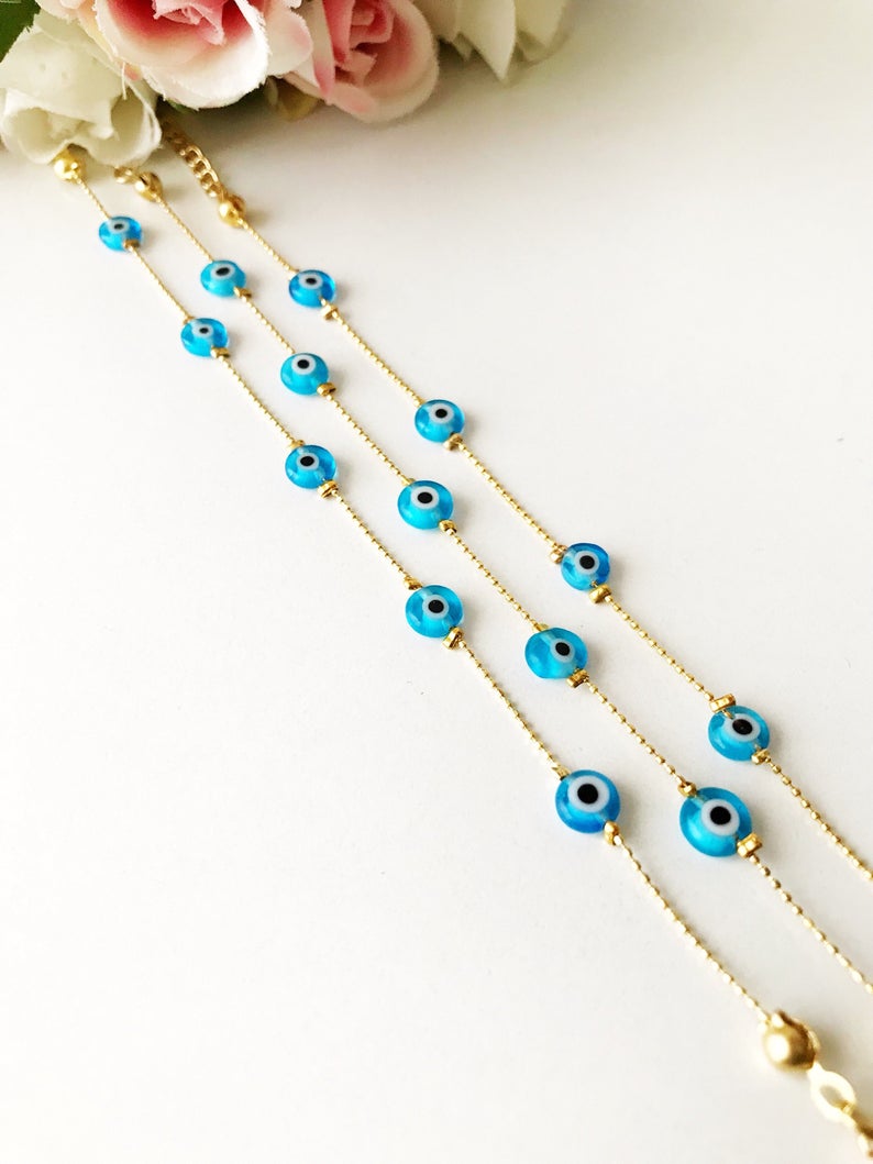 Minimalist Evil Eye Bracelet featuring turquoise beads and a delicate gold chain, showcasing five tiny glass evil eye beads.