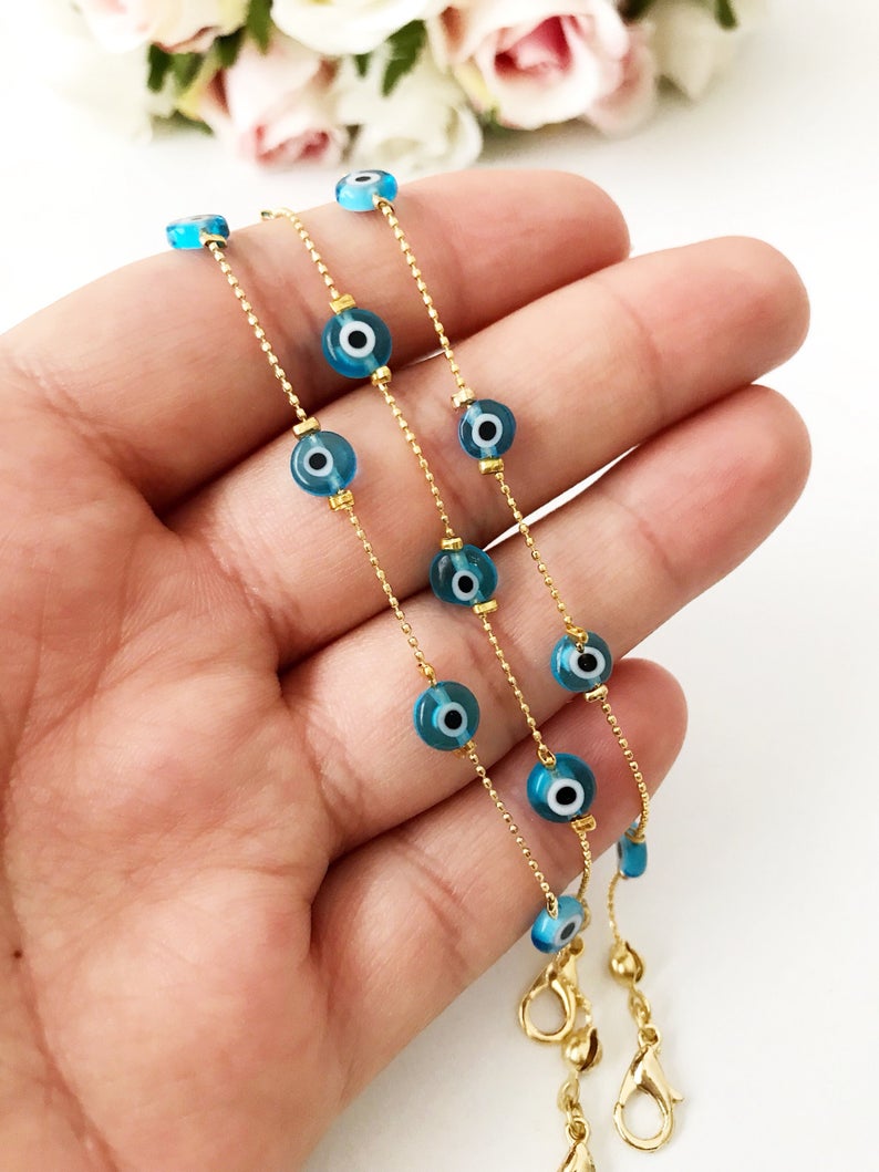 Minimalist Evil Eye Bracelet featuring turquoise beads and a delicate gold chain, showcasing five tiny glass evil eye beads.