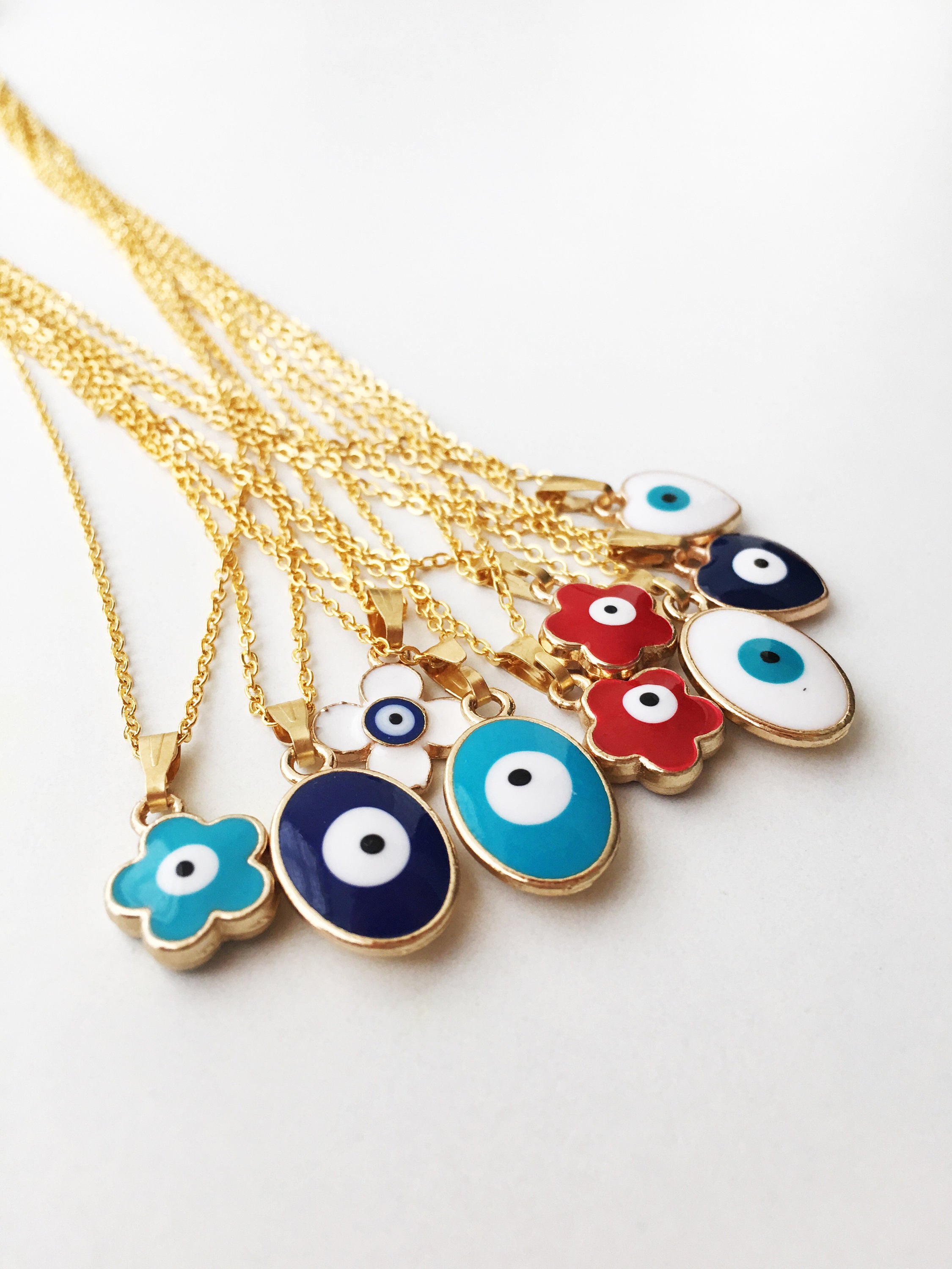 A stunning gold Minimalist Evil Eye Charm Necklace featuring a unique evil eye charm, elegantly displayed on a soft background.