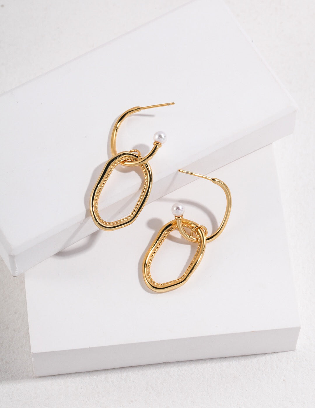 Minimalist geometric earrings featuring faux pearls, sterling silver, and gold vermeil, elegantly designed for a modern look.