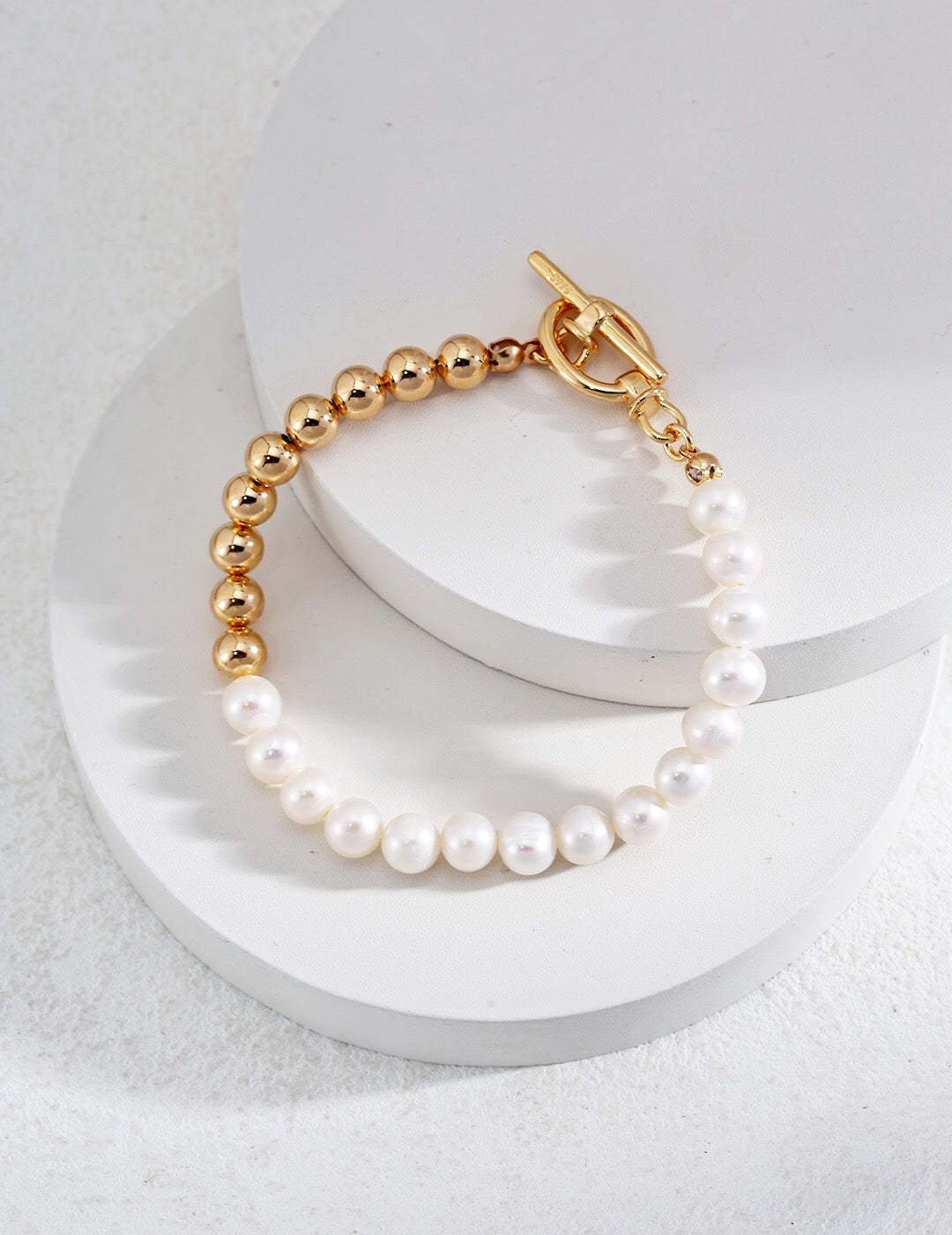 A delicate Minimalist Half Beaded Pearl Bracelet featuring genuine freshwater pearls and gold vermeil accents, elegantly displayed on a soft surface.