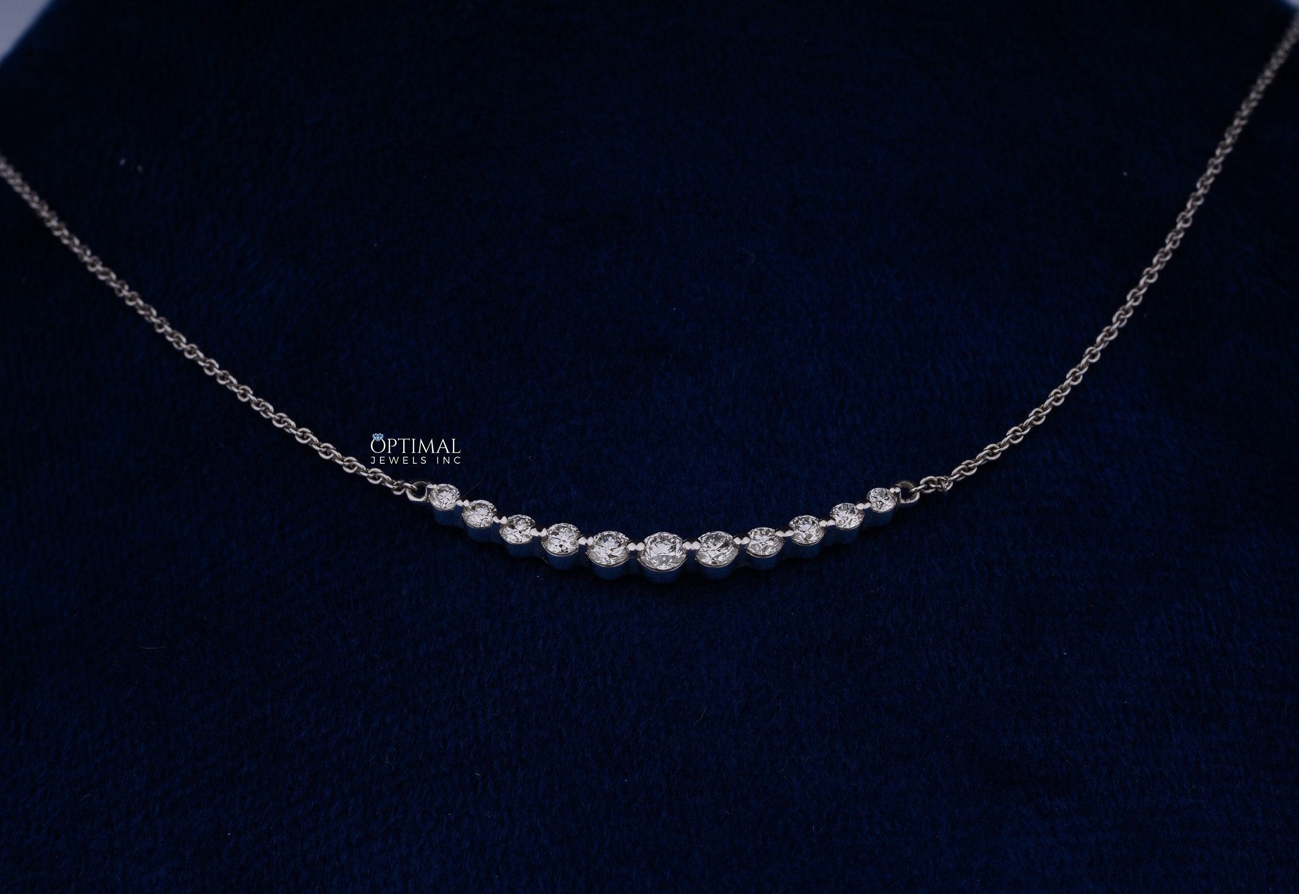 A minimalist lab grown diamond necklace featuring 0.90 Ctw bezel set round cut diamonds on an 18-inch white gold chain, elegantly displayed.