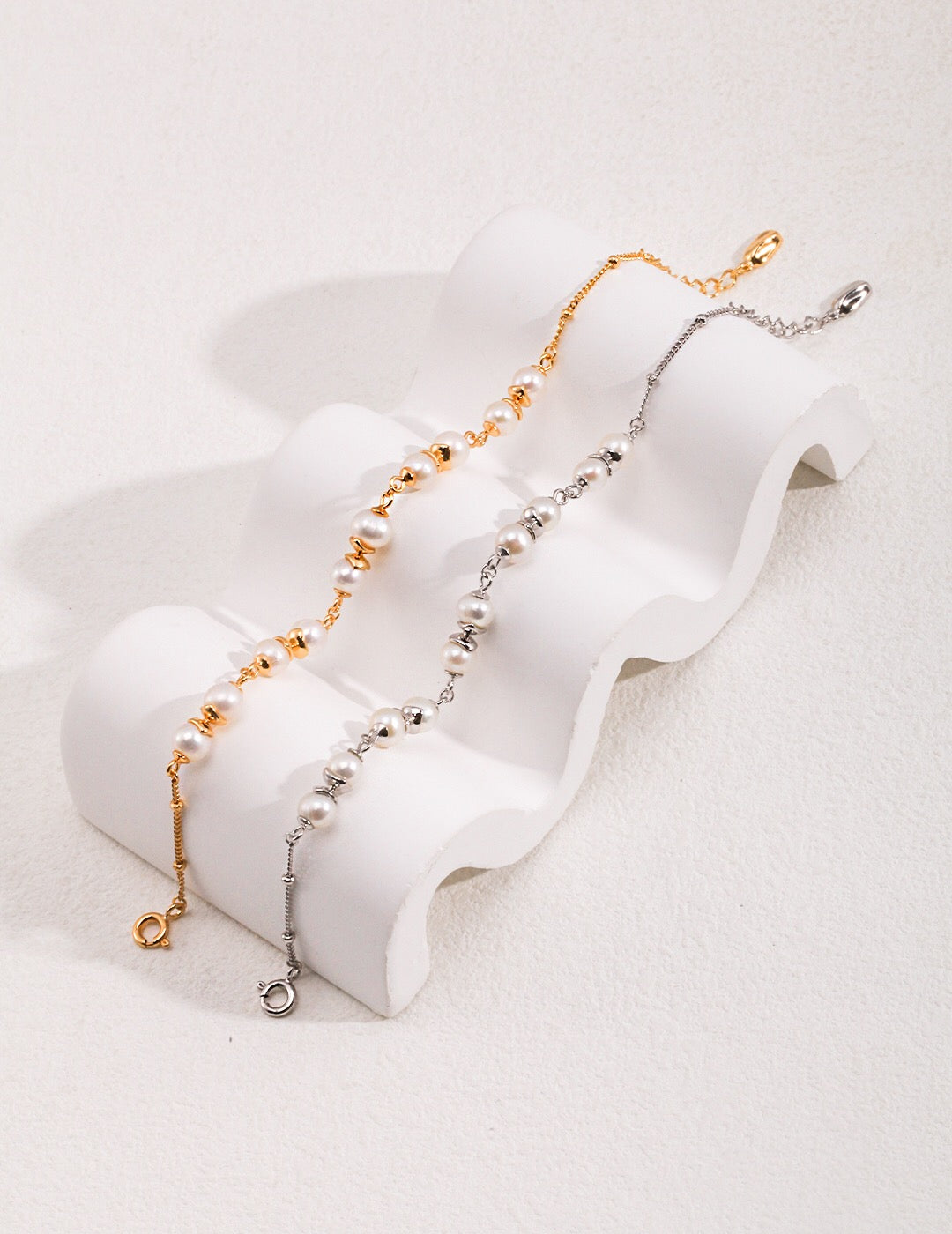 A delicate Minimalist Style Pearl Spacer Bracelet featuring genuine freshwater pearls and gold vermeil accents, elegantly displayed on a soft surface.
