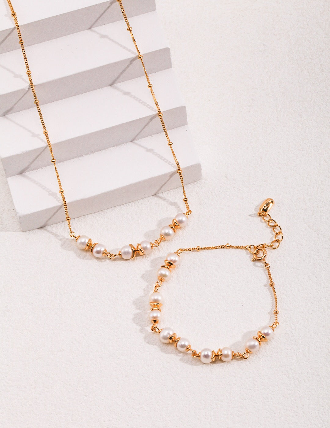 A delicate Minimalist Style Pearl Spacer Bracelet featuring genuine freshwater pearls and gold vermeil accents, elegantly displayed on a soft surface.