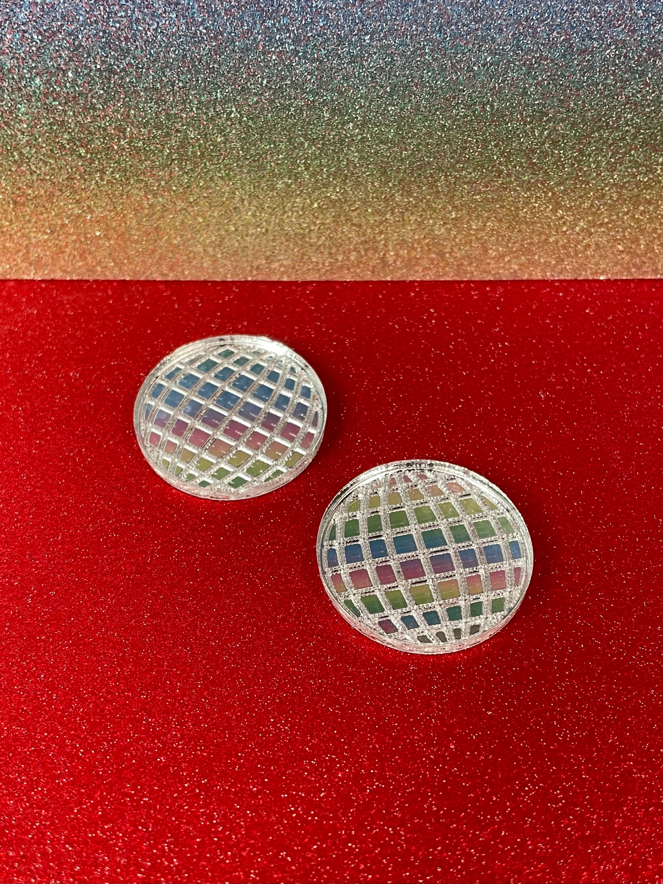 A pair of dazzling Mirror Ball Earrings featuring colorful mirror finishes, available as dangles or studs, showcasing their unique design.