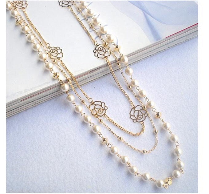 Multi-layer pearl necklace adorned with roses and rhinestones, showcasing elegance and sophistication.