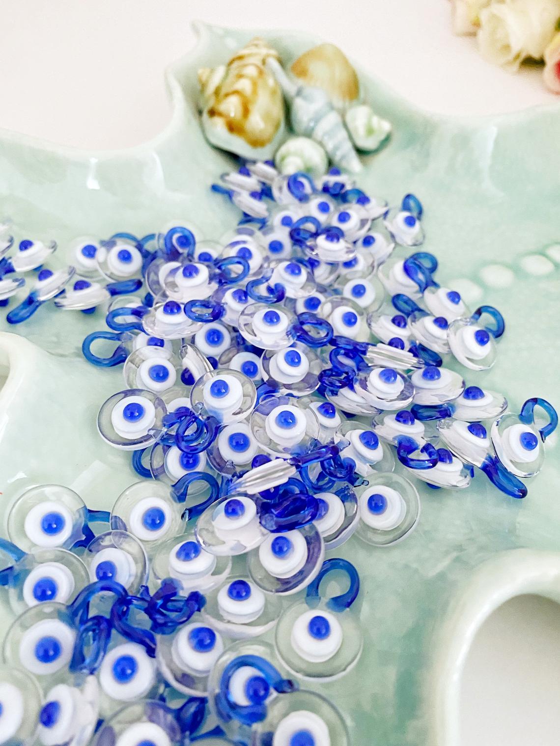A collection of 100 Murano Evil Eye Beads in clear and blue colors, showcasing their intricate designs and craftsmanship.