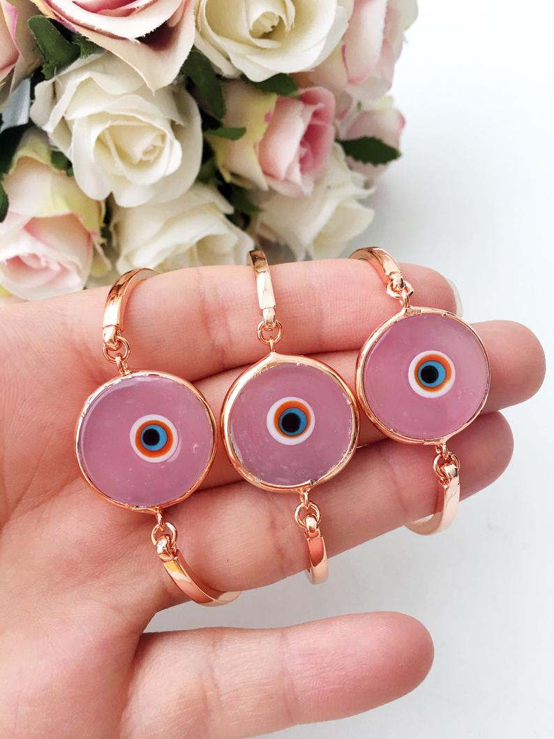 A delicate baby pink Murano Evil Eye Bracelet featuring a rose gold chain and intricate glass evil eye charm.