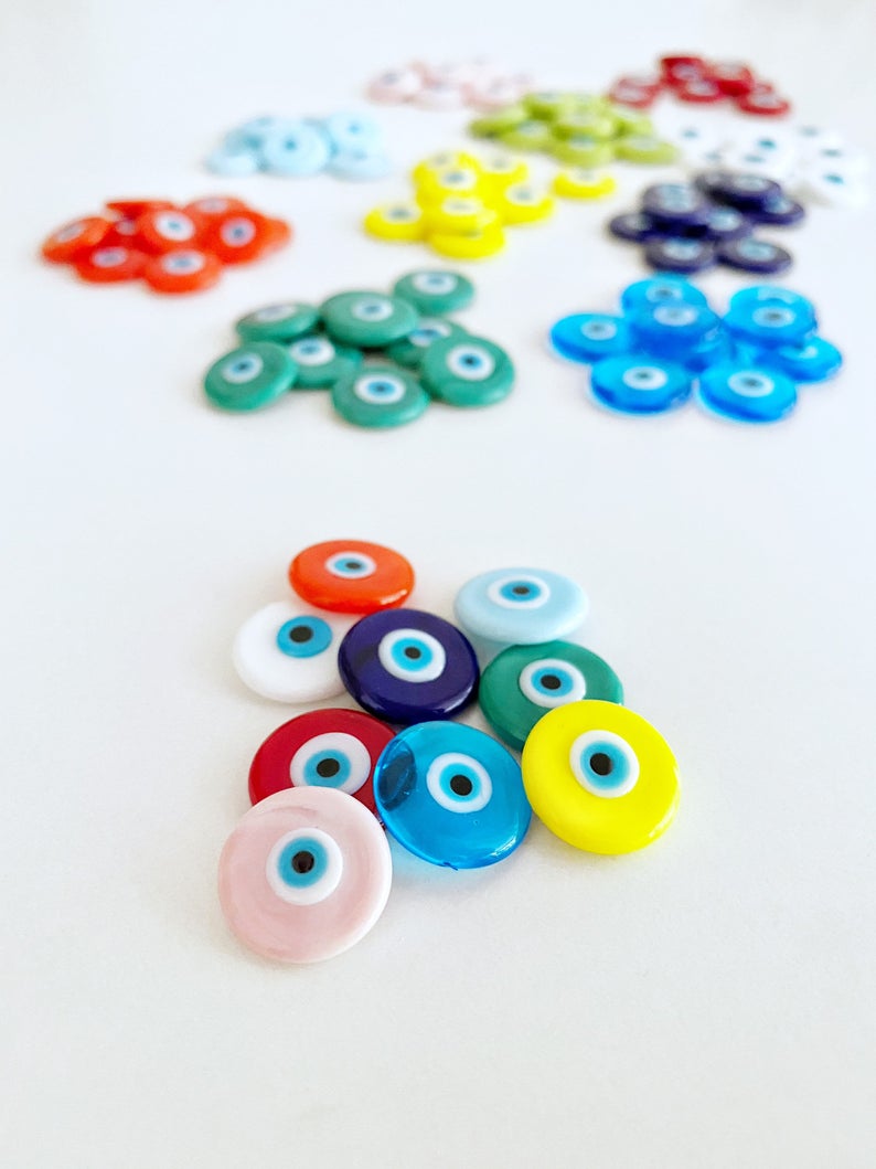A collection of 15mm Murano Evil Eye Cabochons in various colors, showcasing their intricate designs and glass craftsmanship.