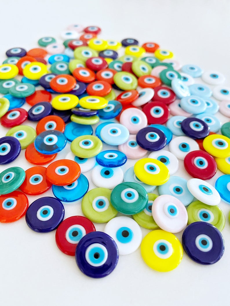 A collection of 15mm Murano Evil Eye Cabochons in various colors, showcasing their intricate designs and glass craftsmanship.