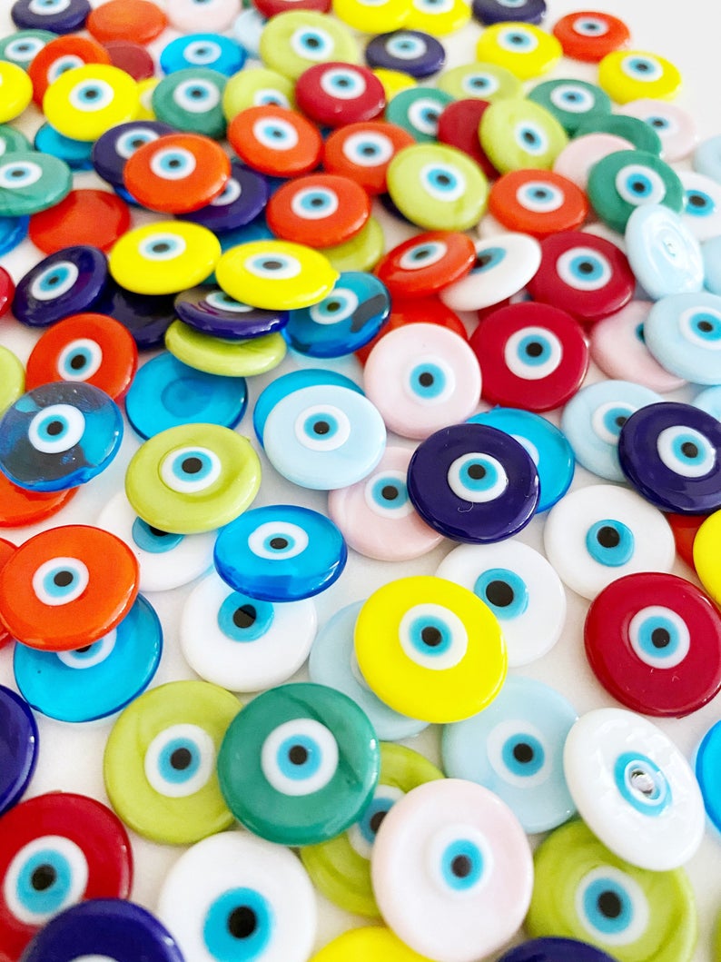 A collection of 15mm Murano Evil Eye Cabochons in various colors, showcasing their intricate designs and glass craftsmanship.