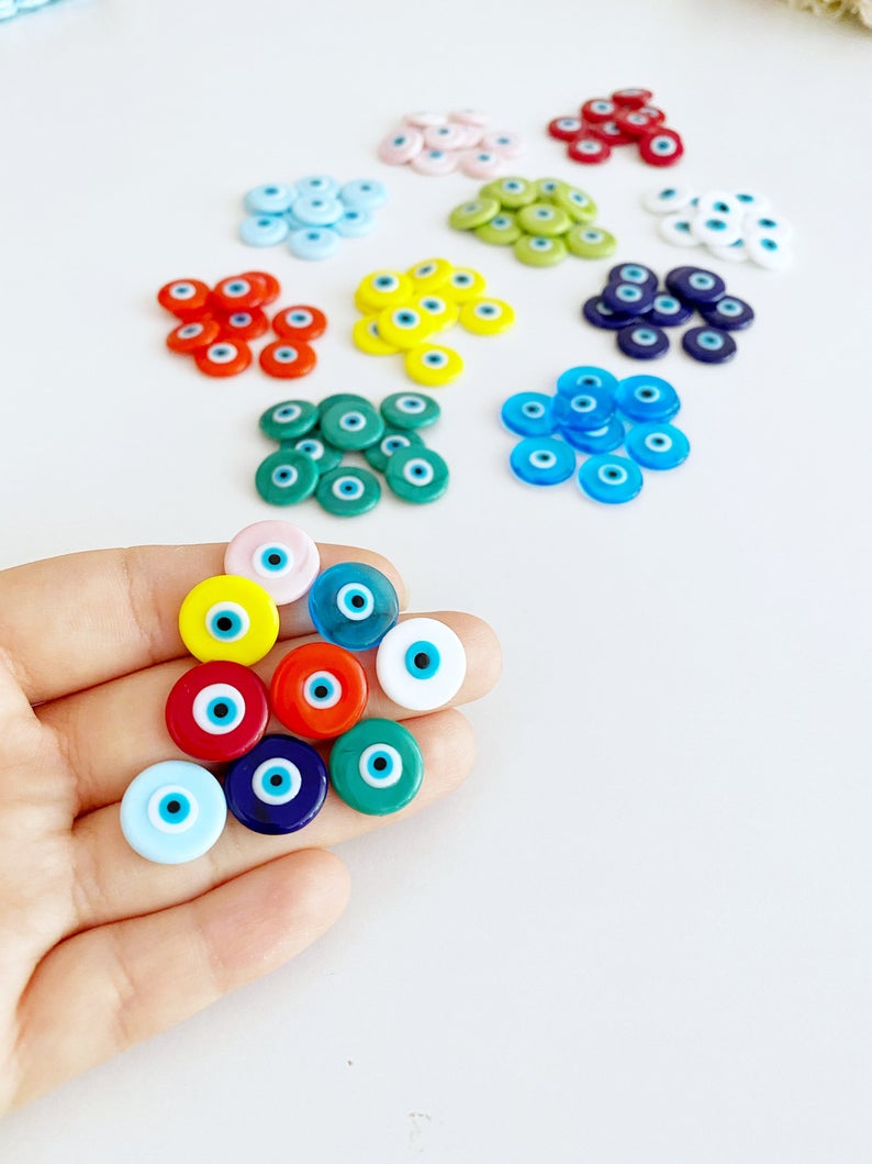 A collection of 15mm Murano Evil Eye Cabochons in various colors, showcasing their intricate designs and glass craftsmanship.