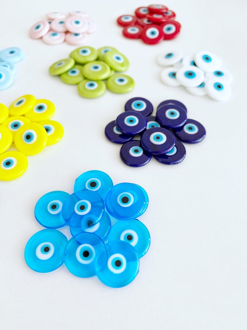A collection of 15mm Murano Evil Eye Cabochons in various colors, showcasing their intricate designs and glass craftsmanship.