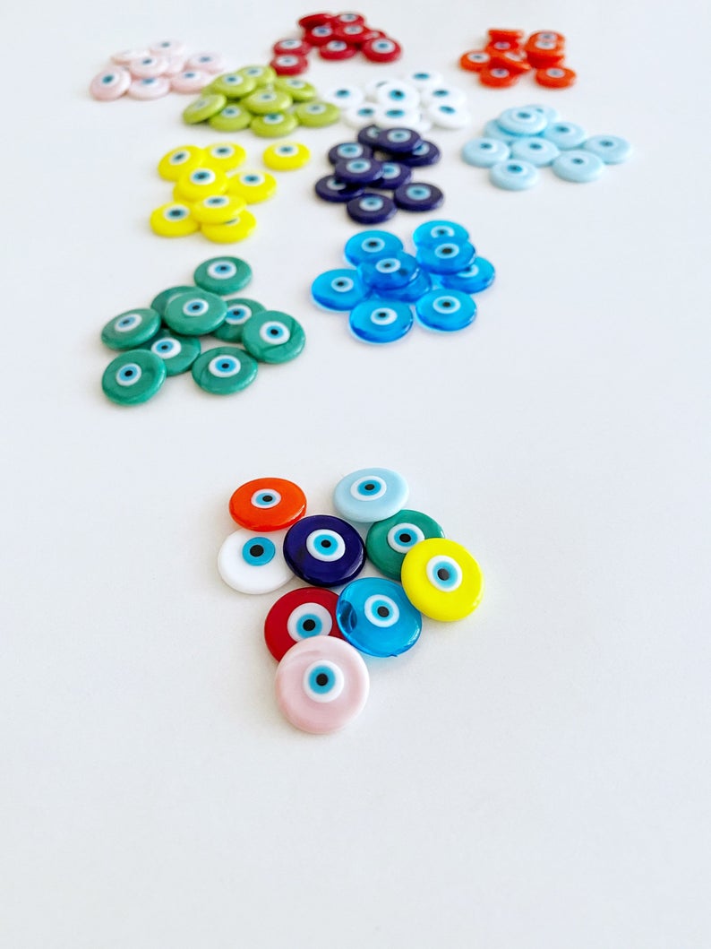 A collection of 15mm Murano Evil Eye Cabochons in various colors, showcasing their intricate designs and glass craftsmanship.