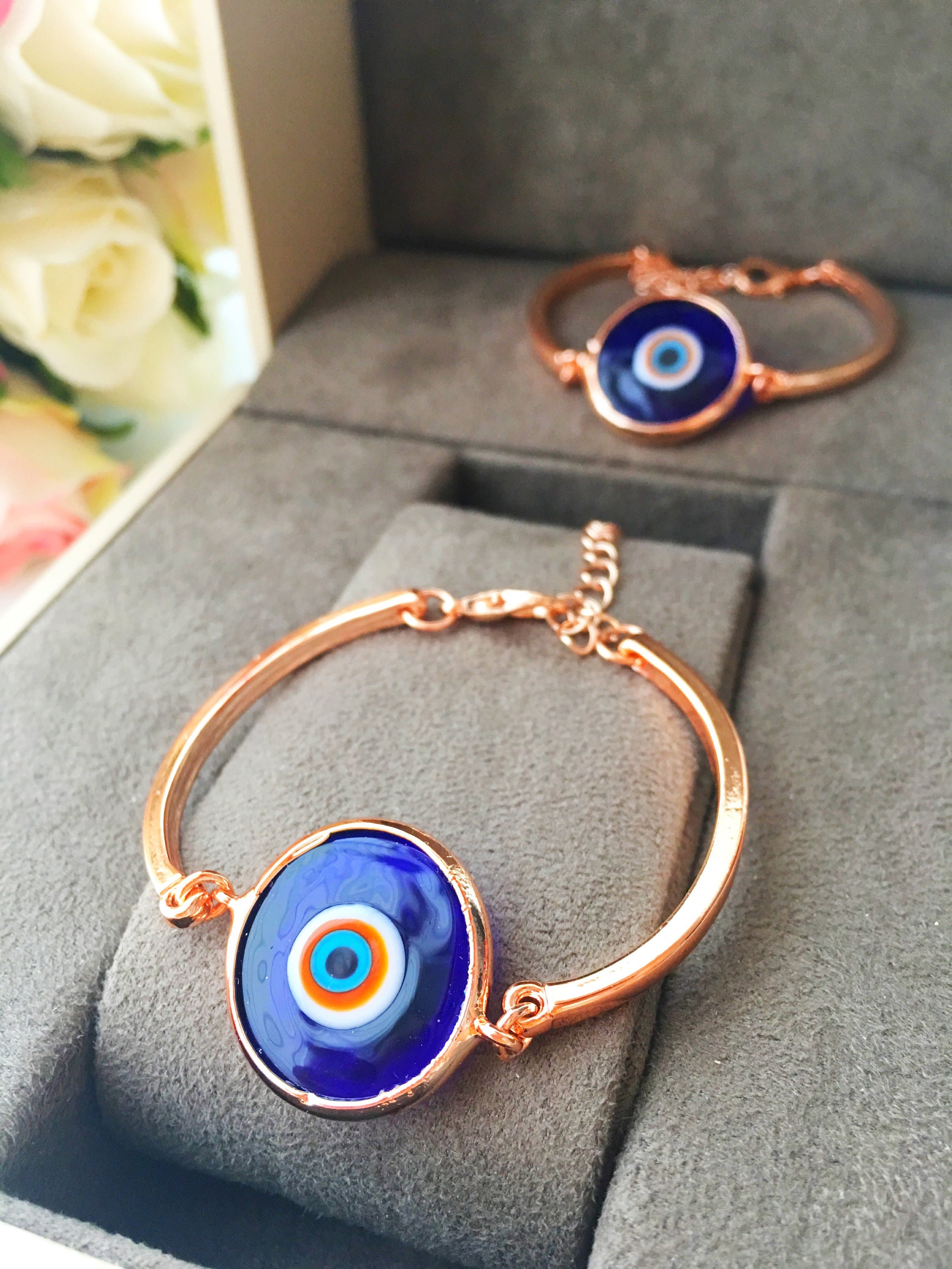 A collection of Murano Evil Eye Charm Bracelets in various colors including dark blue, baby blue, turquoise, baby pink, and white, showcasing their unique glass charms.
