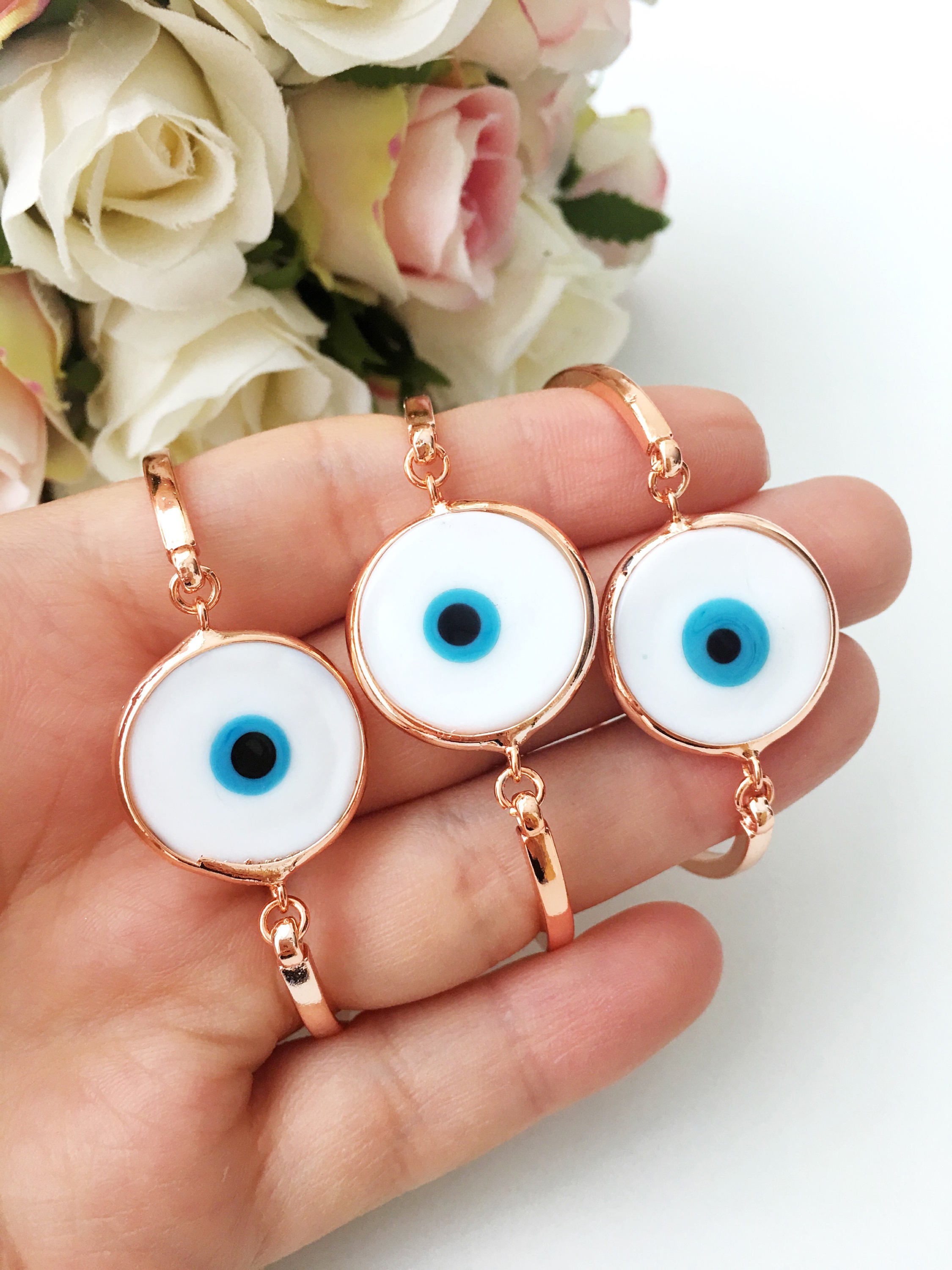 A collection of Murano Evil Eye Charm Bracelets in various colors including dark blue, baby blue, turquoise, baby pink, and white, showcasing their unique glass charms.