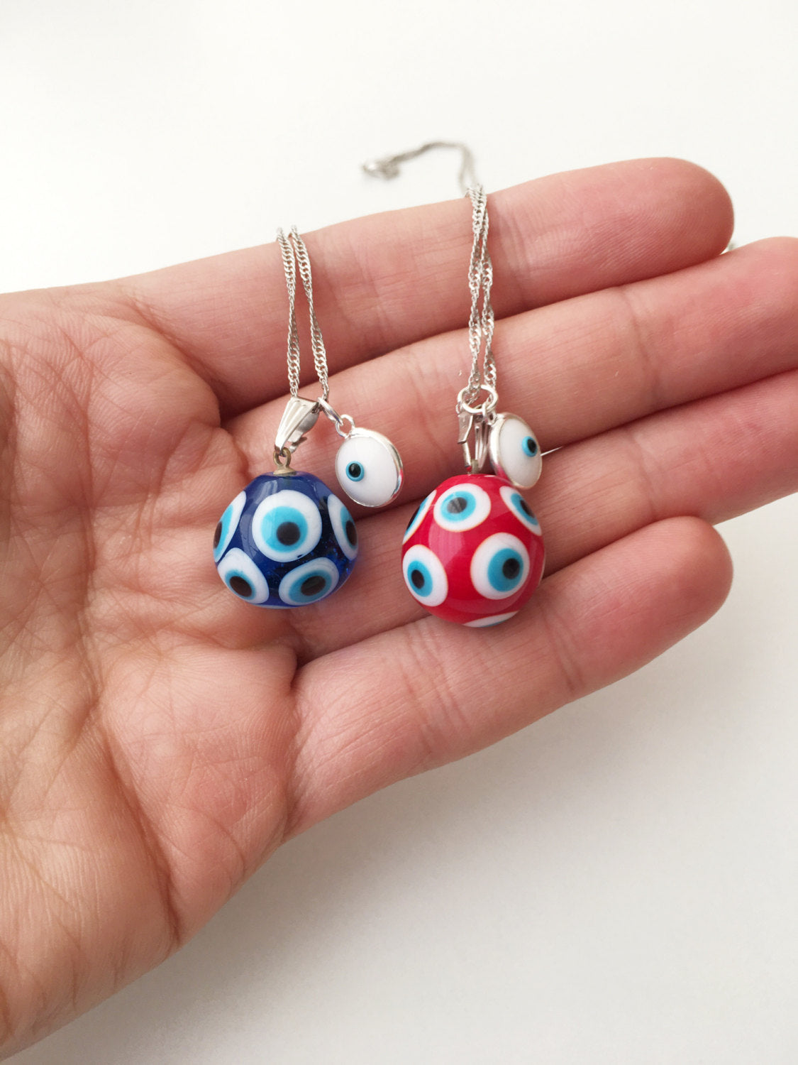 Murano Evil Eye Necklace featuring a large blue and red evil eye bead with a tiny white evil eye bead, showcasing intricate glass craftsmanship.