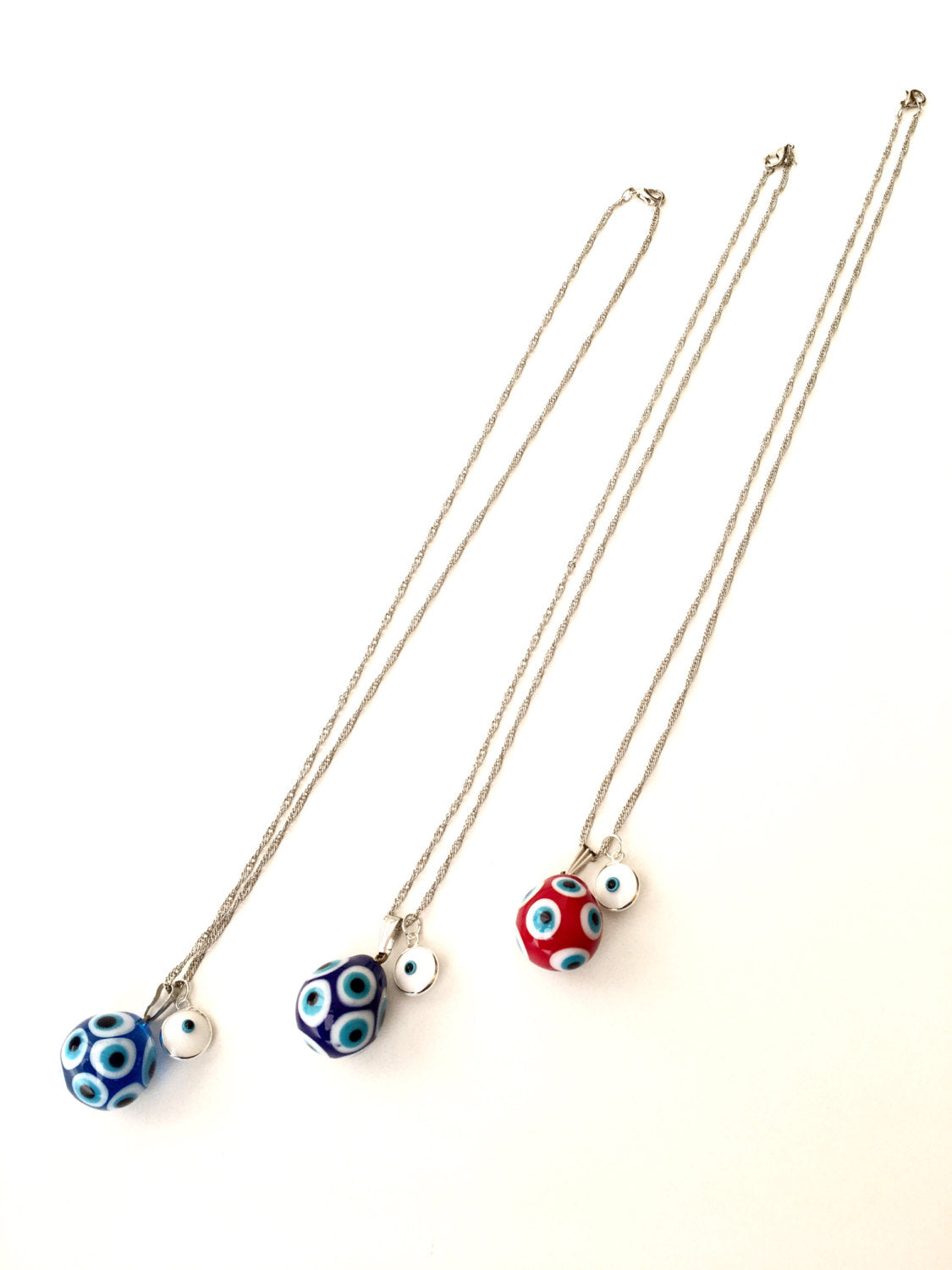 Murano Evil Eye Necklace featuring a large blue and red evil eye bead with a tiny white evil eye bead, showcasing intricate glass craftsmanship.