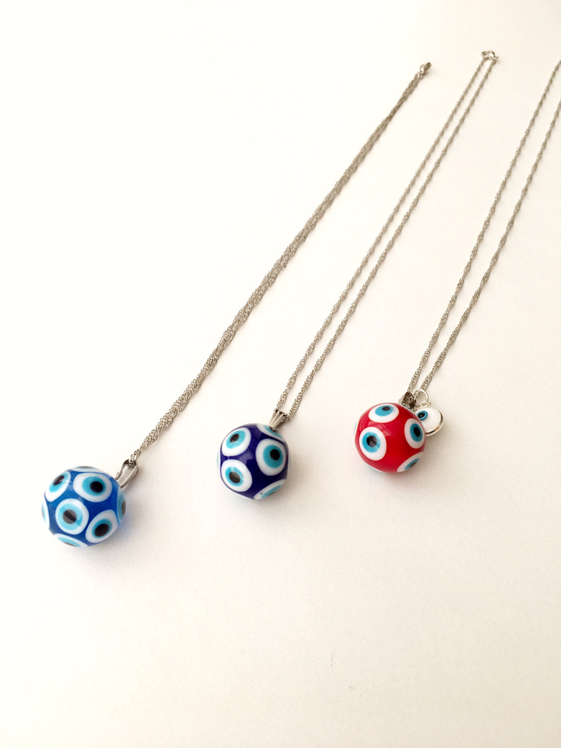 Murano Evil Eye Necklace featuring a large blue and red evil eye bead with a tiny white evil eye bead, showcasing intricate glass craftsmanship.
