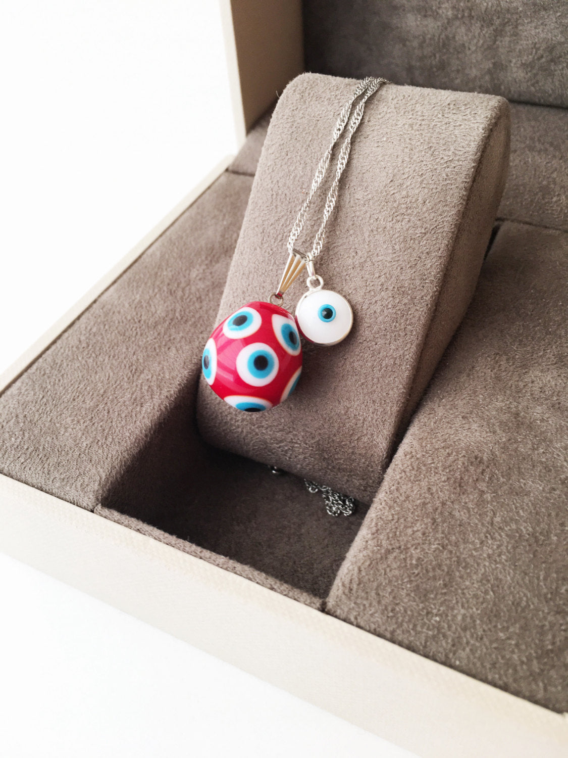 Murano Evil Eye Necklace featuring a large blue and red evil eye bead with a tiny white evil eye bead, showcasing intricate glass craftsmanship.