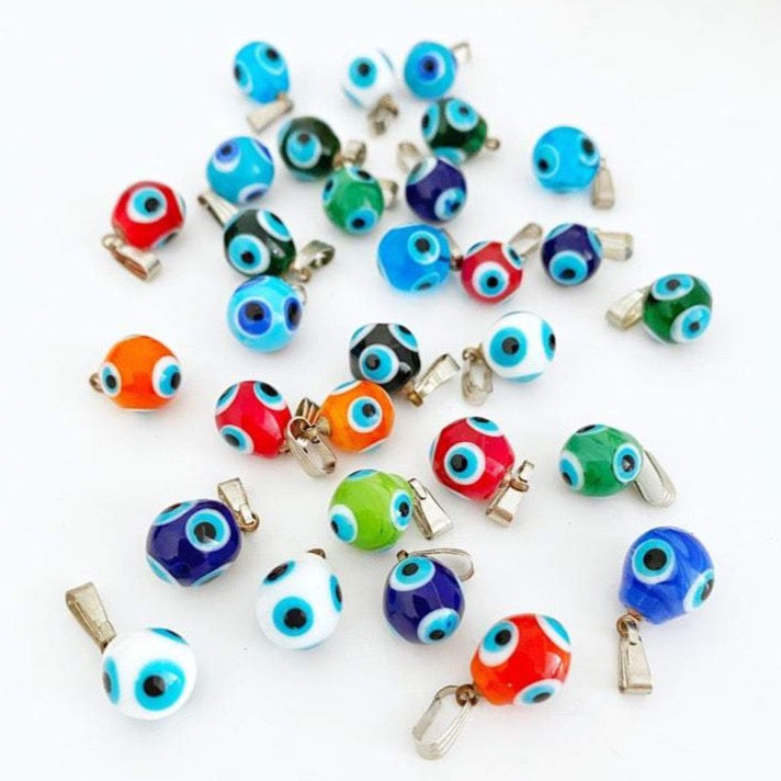 Three handmade Murano glass evil eye pendants in vibrant colors, showcasing intricate designs and a protective symbol.