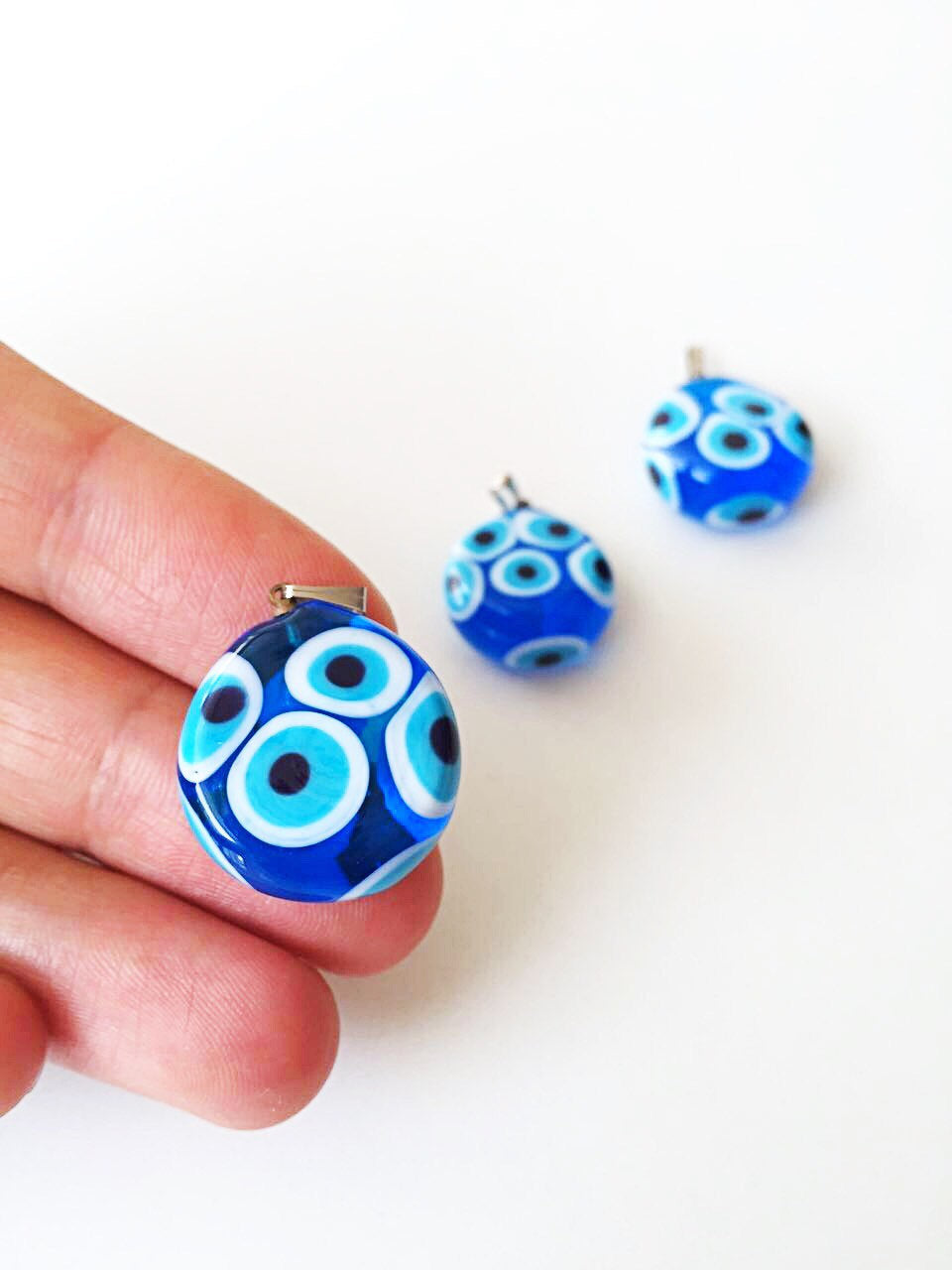 Handmade Murano glass evil eye pendant featuring a vibrant blue lampwork bead, symbolizing protection and good luck.