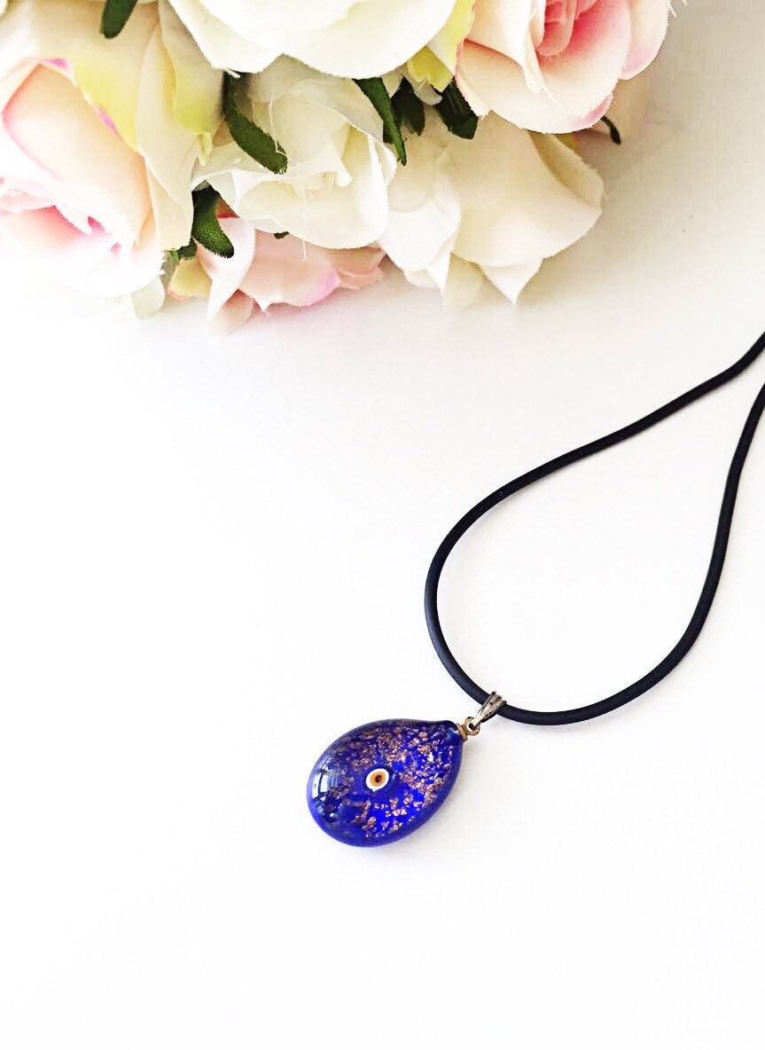 Handcrafted Murano glass evil eye pendant in vibrant blue, featuring intricate lampwork design, symbolizing protection and style.