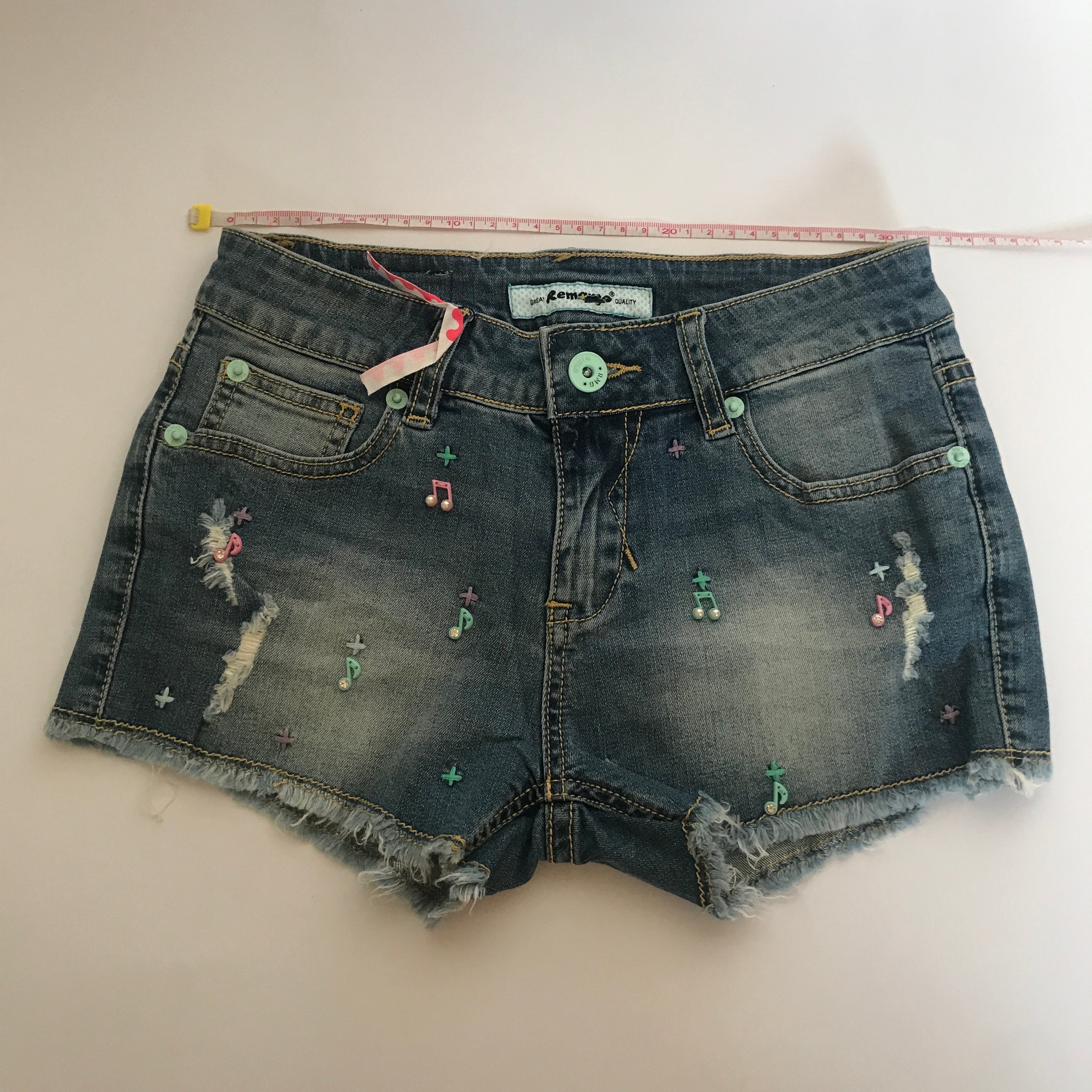A pair of stylish denim shorts featuring a unique music notes design, made from a comfortable cotton and spandex blend.