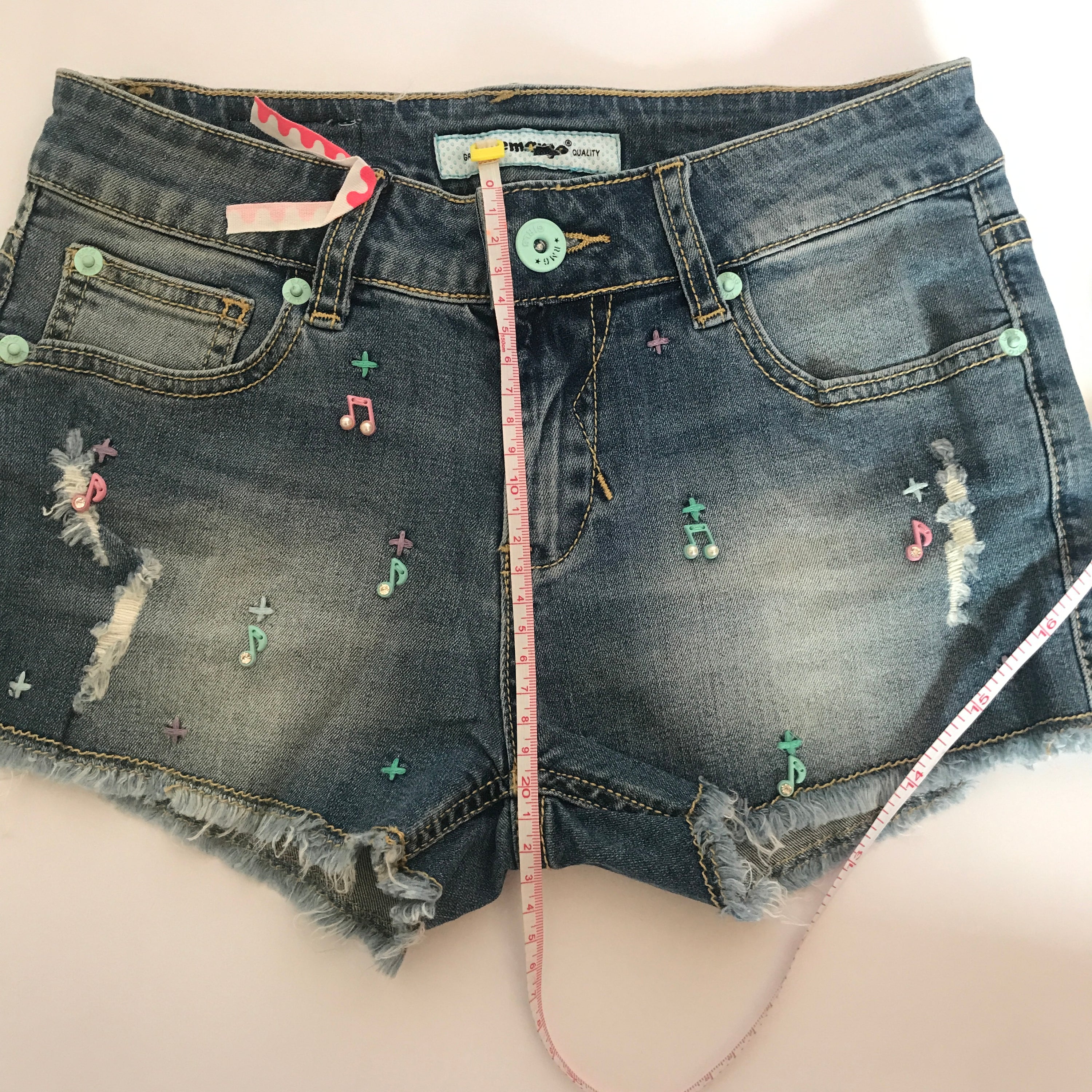 A pair of stylish denim shorts featuring a unique music notes design, made from a comfortable cotton and spandex blend.
